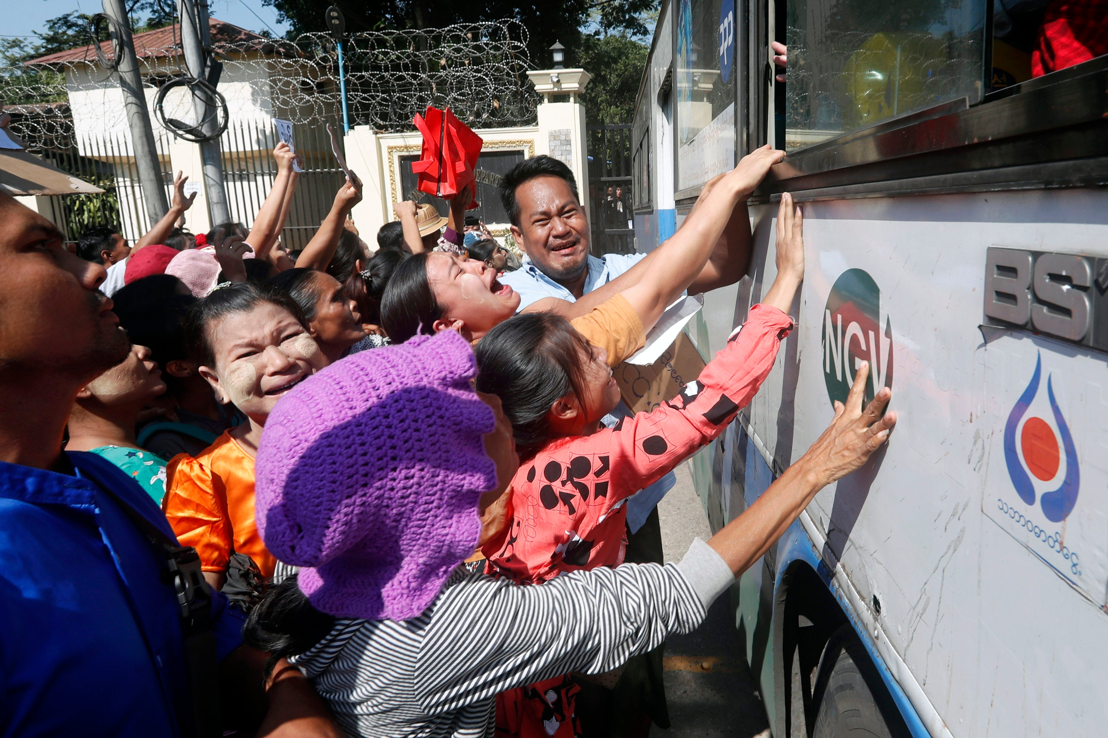 Relatives react as a bus carrying released inmates exits Insein prison in Yangon, Myanmar