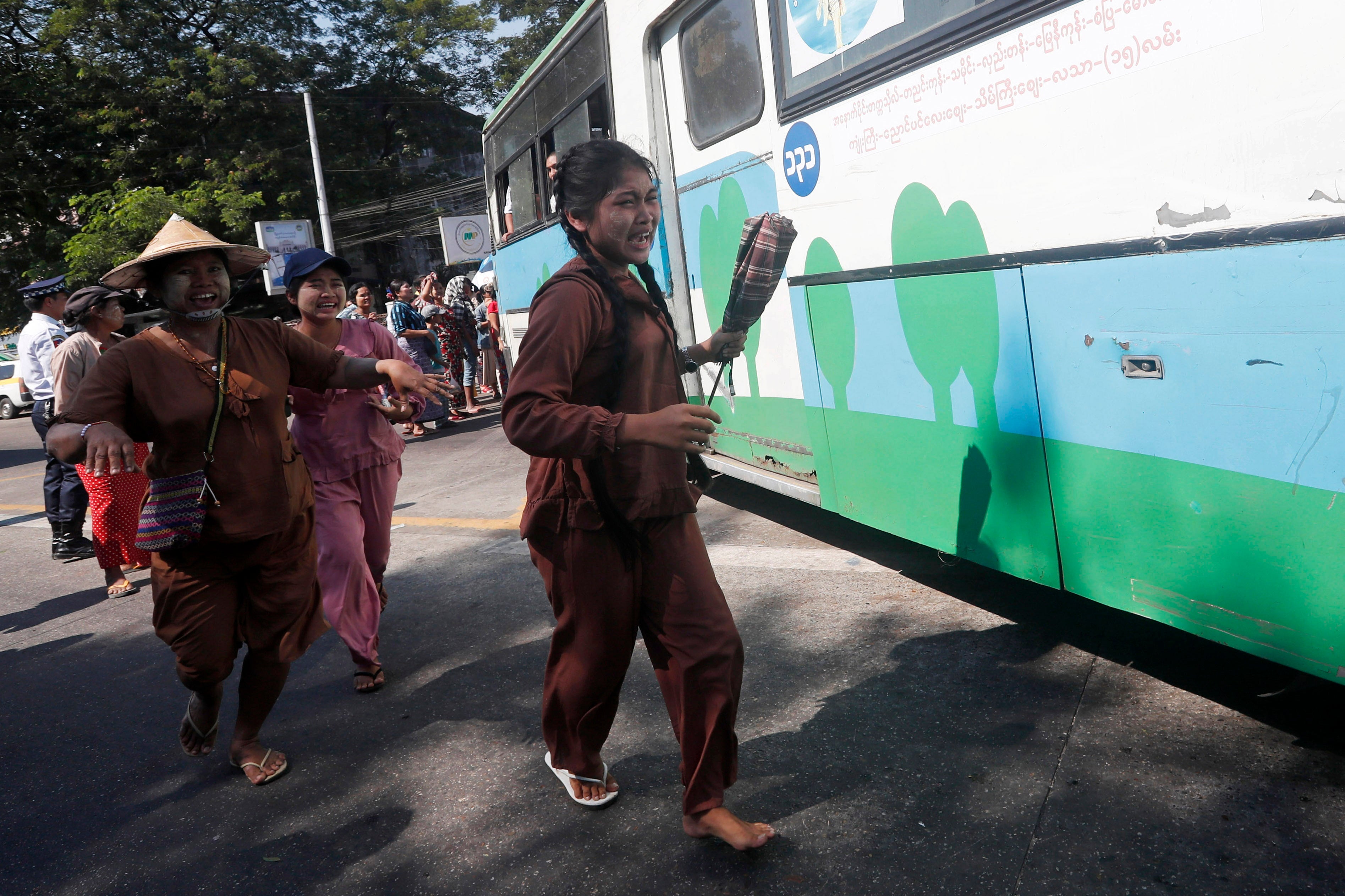 Relatives react as a bus carrying released inmates exits Insein prison in Yangon, Myanmar