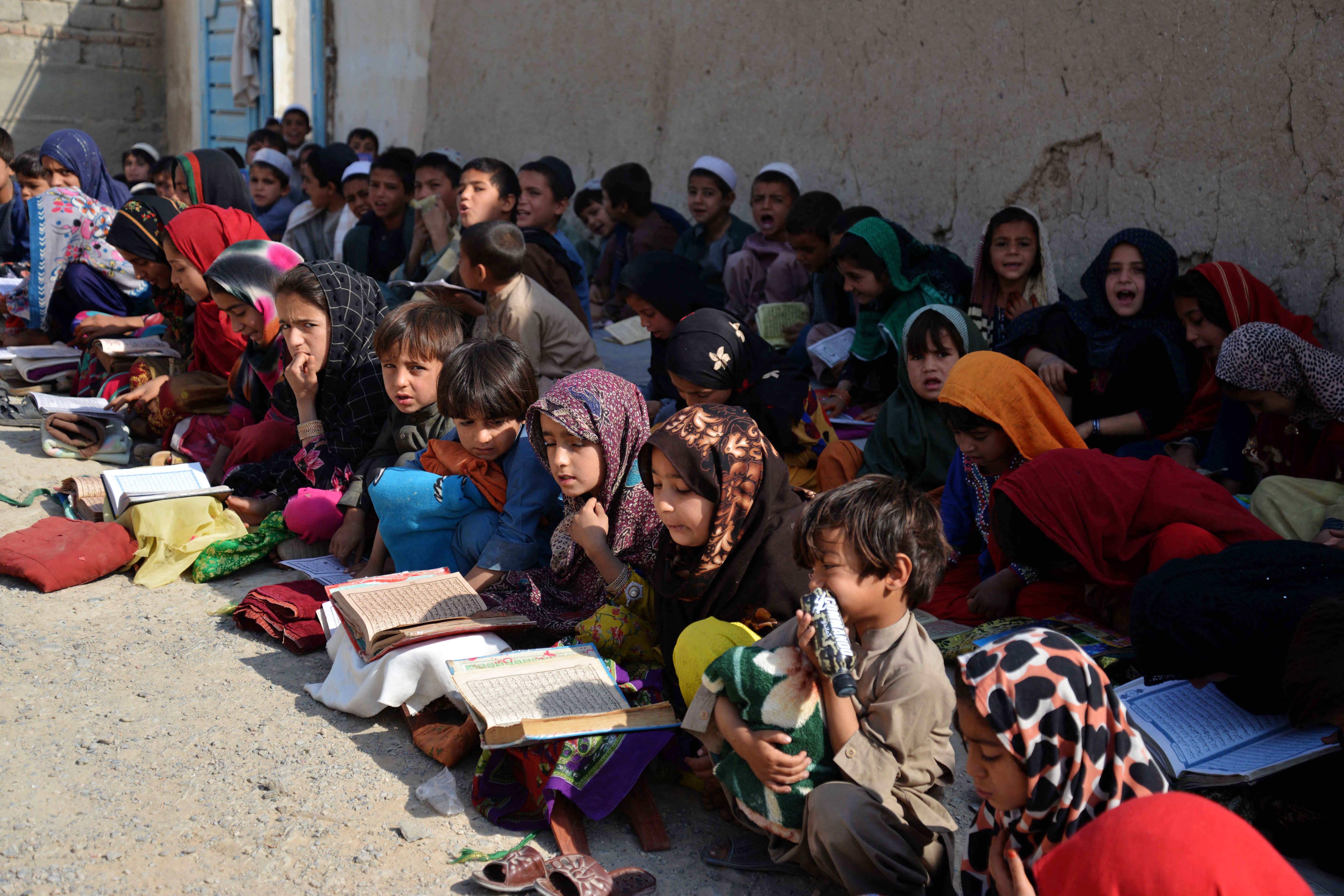 Afghan children study the Quran at an open air madrassa or an Islamic school on the outskirts of Kandahar province