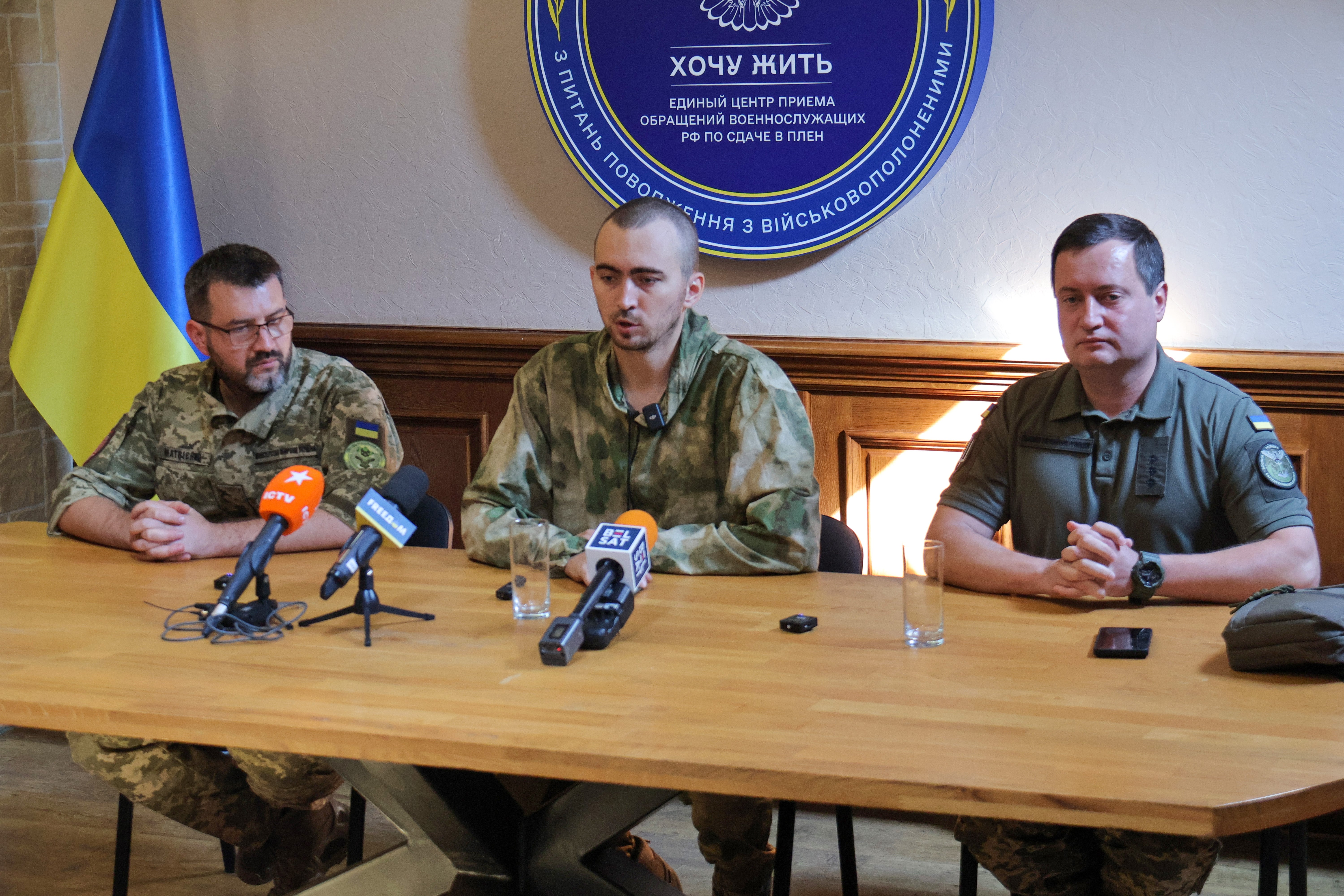 I Want To Live project spokesperson Vitalii Matviienko (L) alongside Russian military officer Danil Alfyorov (C)