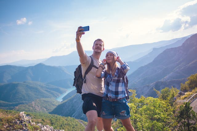 <p>File photo: A couple take a selfie at the top of a mountain </p>