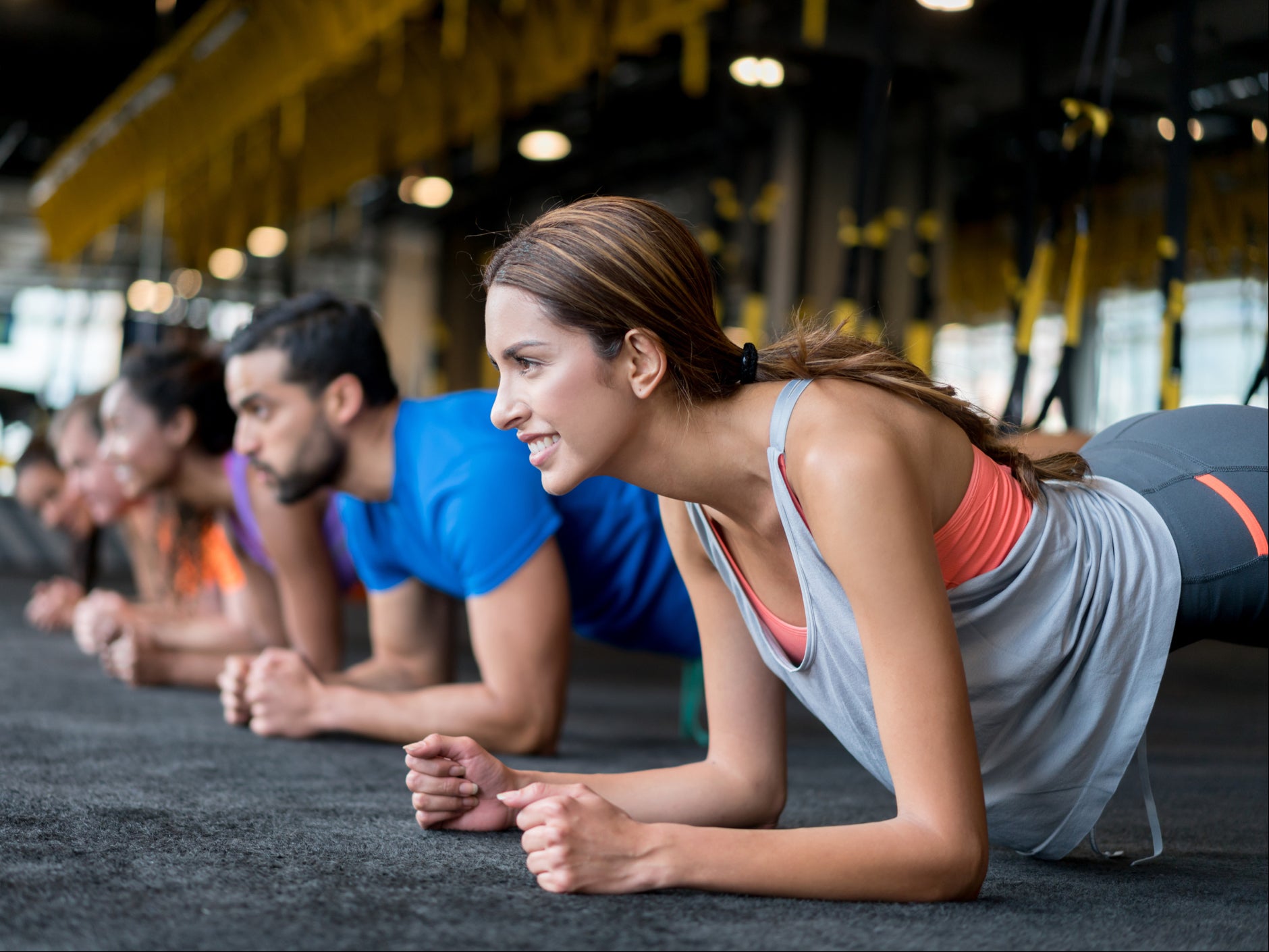 Group of people exercising at the gym in a suspension training class