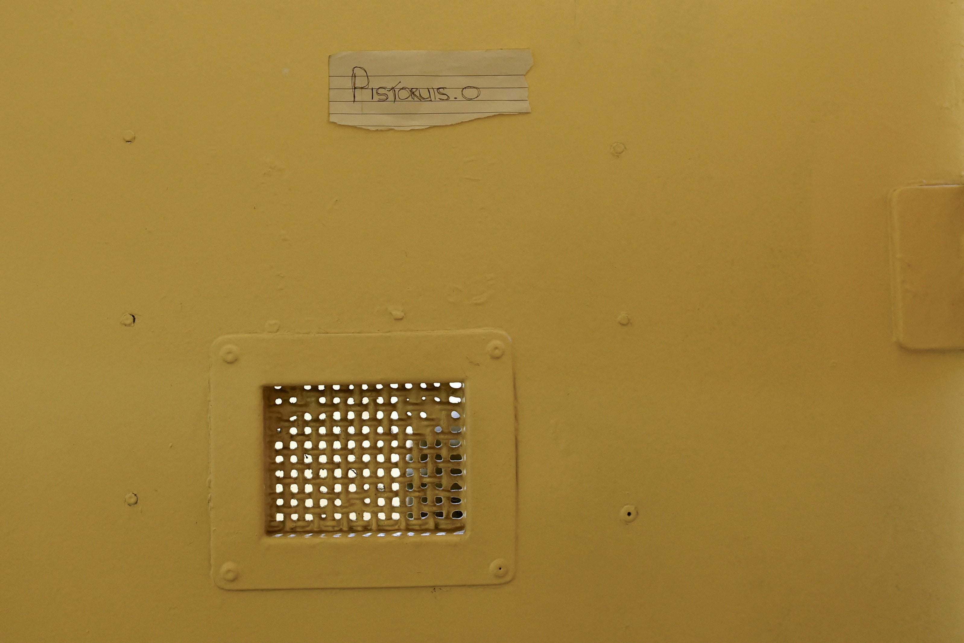 A handwritten and misspelt ‘Pistoruis. O’ is stuck to his cell door