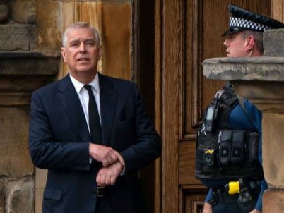A police officer stands alongside Britain's Prince Andrew, Duke of York as they await the arrival of the coffin of Queen Elizabeth II