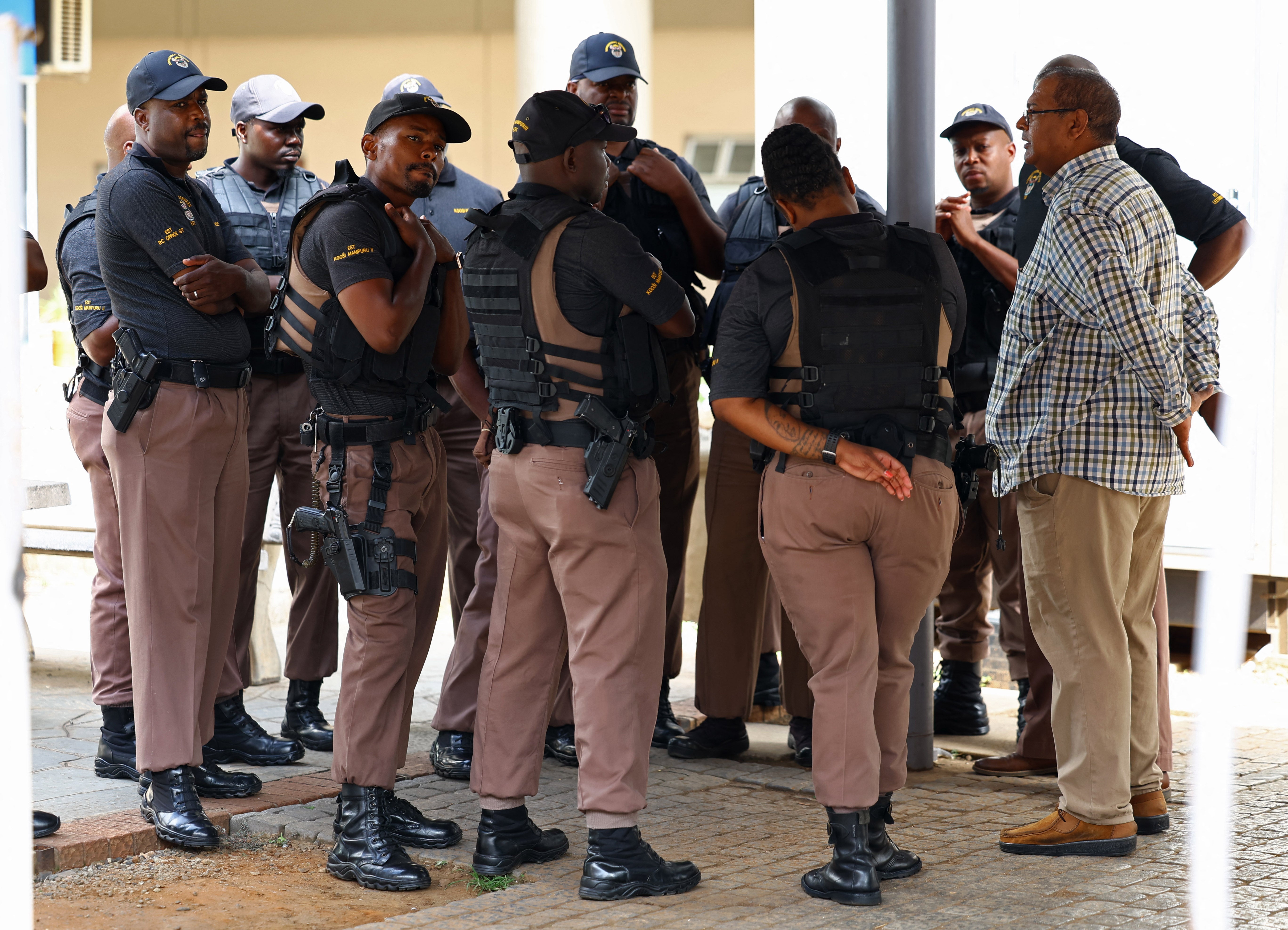 Correctional service emergency support team members look on at the entrance of the National head offices of the correctional services, where parolees are processed