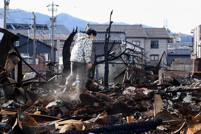 <p>A man looks through the burned Wajima Asa-ichi, or morning market area, in the city of Wajima, Ishikawa prefecture</p>