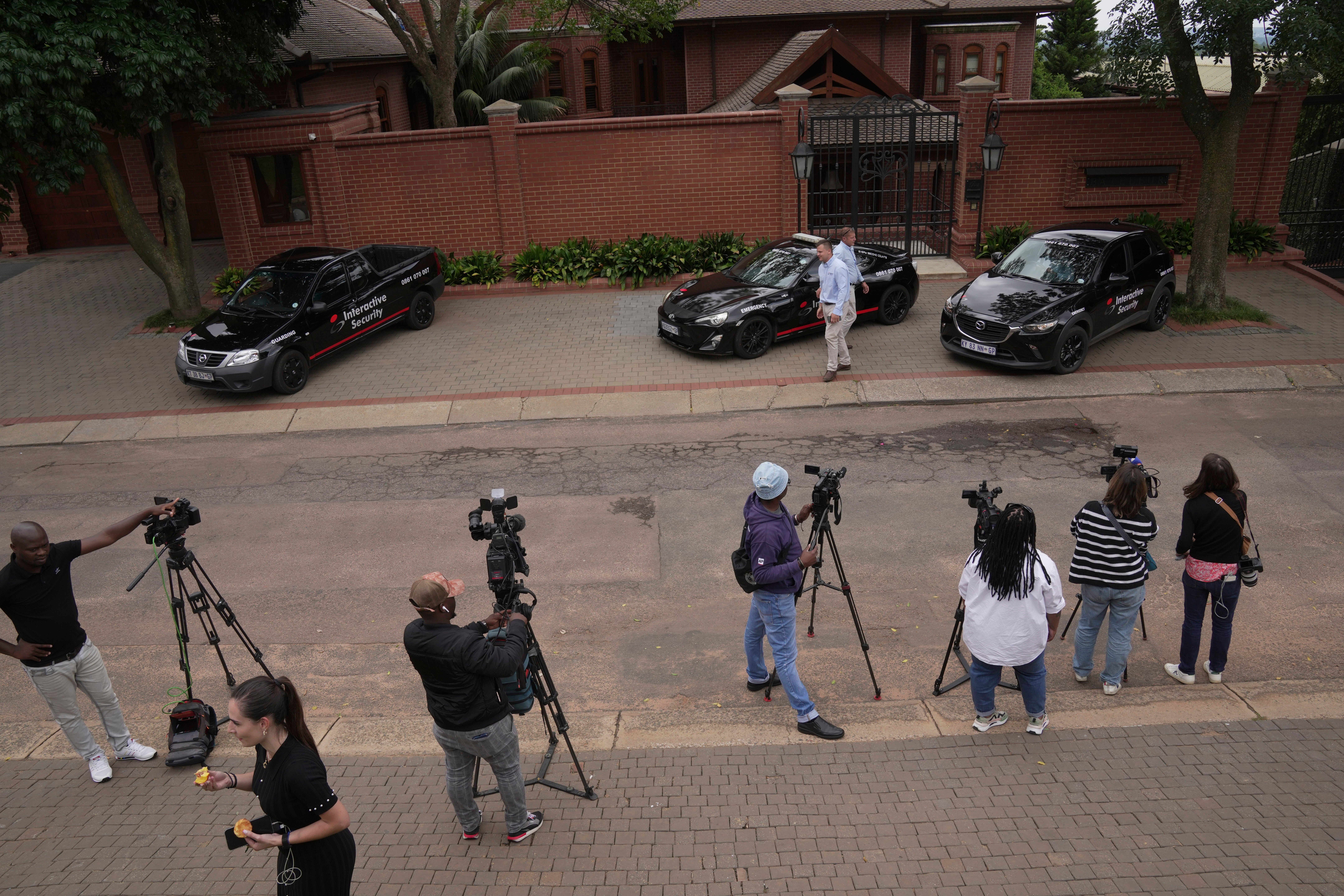 Press gather outside the home of Oscar Pistorius' uncle in the upmarket suburb of Waterkloof