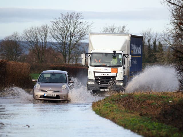 <p>Vehicles driven through a flooded road in Aldingbourne, West Sussex last week  </p>