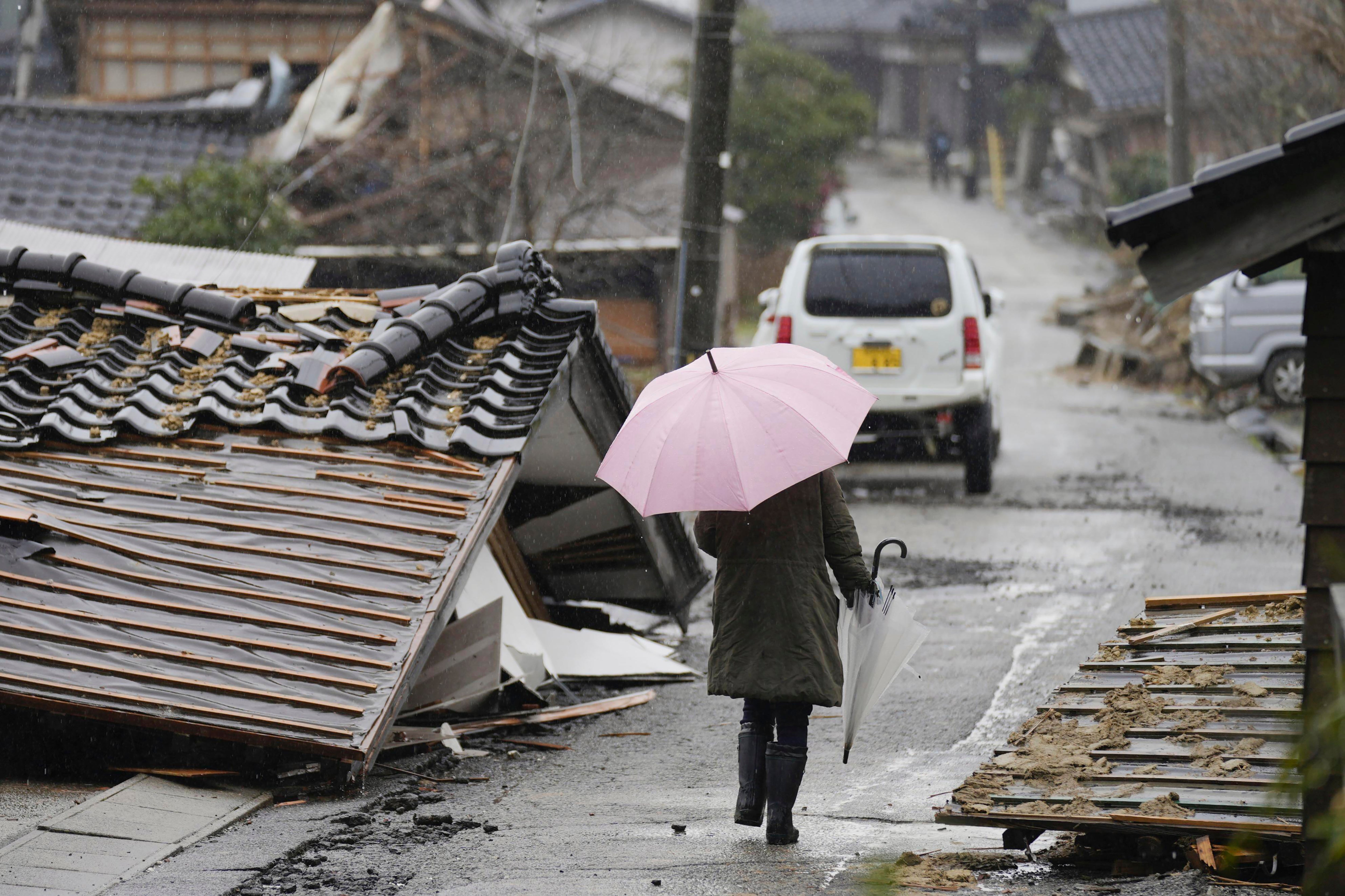 A person walks through the collapsed houses in Suzu, Ishikawa prefecture, Japan on Sunday