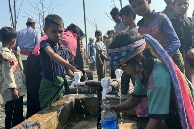 <p>Rohingya refugee children collect drinking water after a midnight fire raced through their refugee camp at Kutupalong in Cox's Bazar district, Bangladesh, Sunday, Jan. 7, 2024. Almost all of Bangladesh depends on well water  </p>
