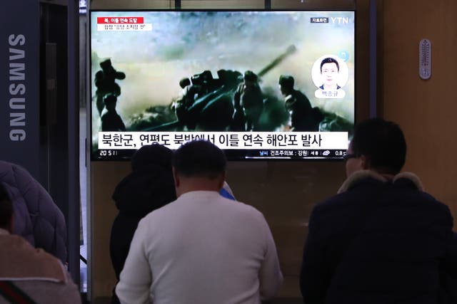 <p>People watch a television screen showing a news broadcast with file footage of North Korea’s artillery firing, at a railway station on January 06, 2024 in Seoul, South Korea</p>