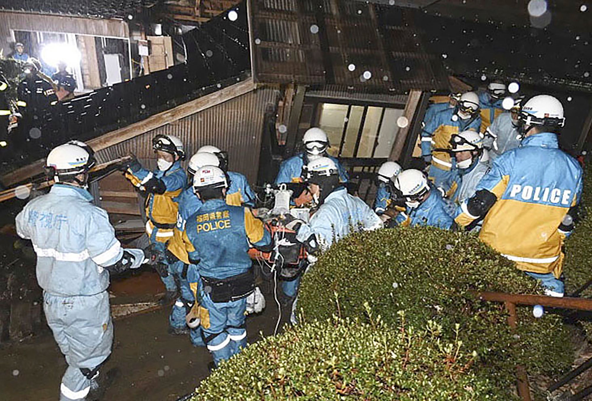 Police officers rescue a woman in her 90s from a collapsed house in Suzu, Ishikawa prefecture, Japan, on Saturday