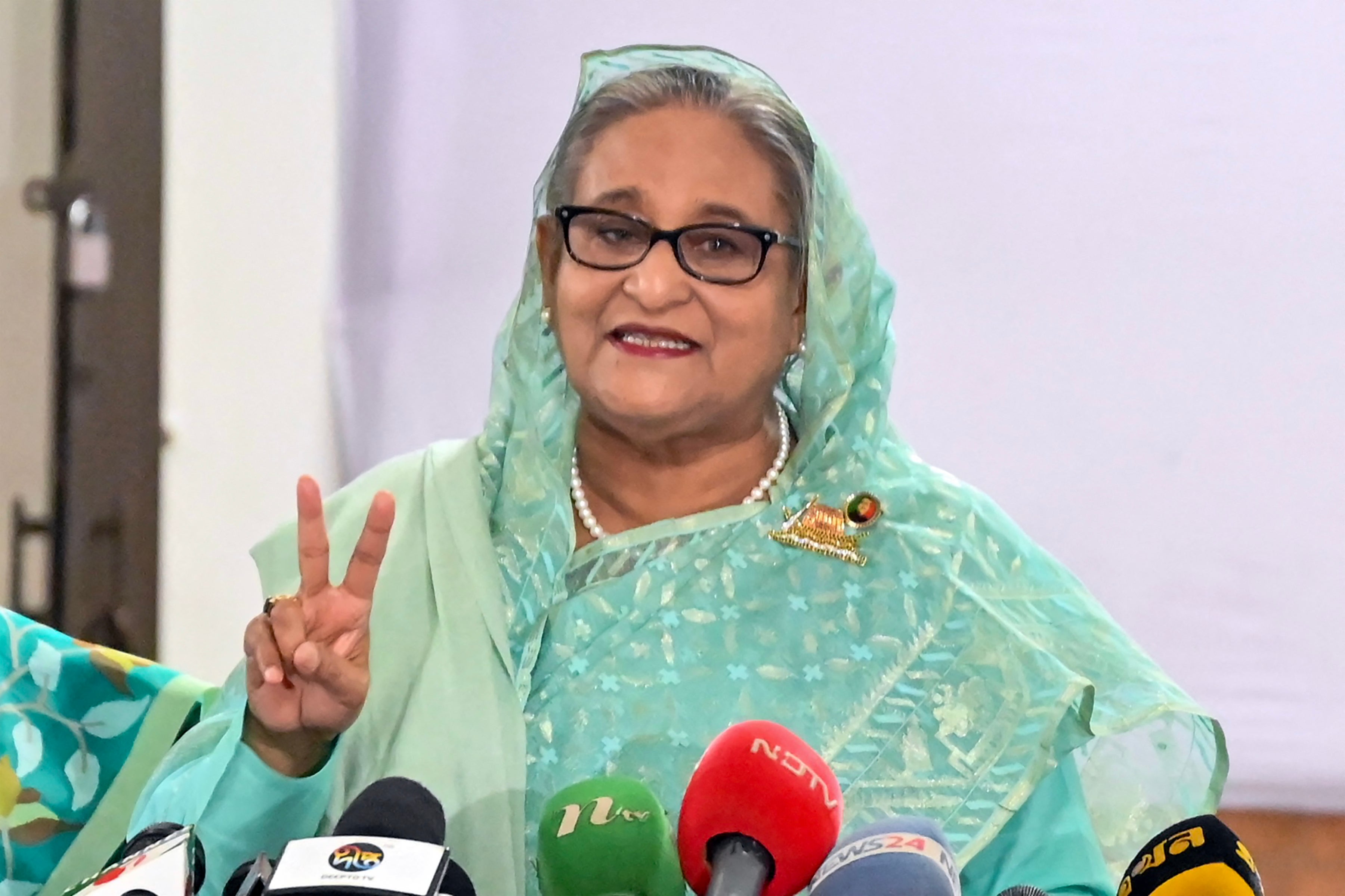 Bangladesh's Prime Minister Sheikh Hasina gestures after casting her vote casts at a polling station in Dhaka