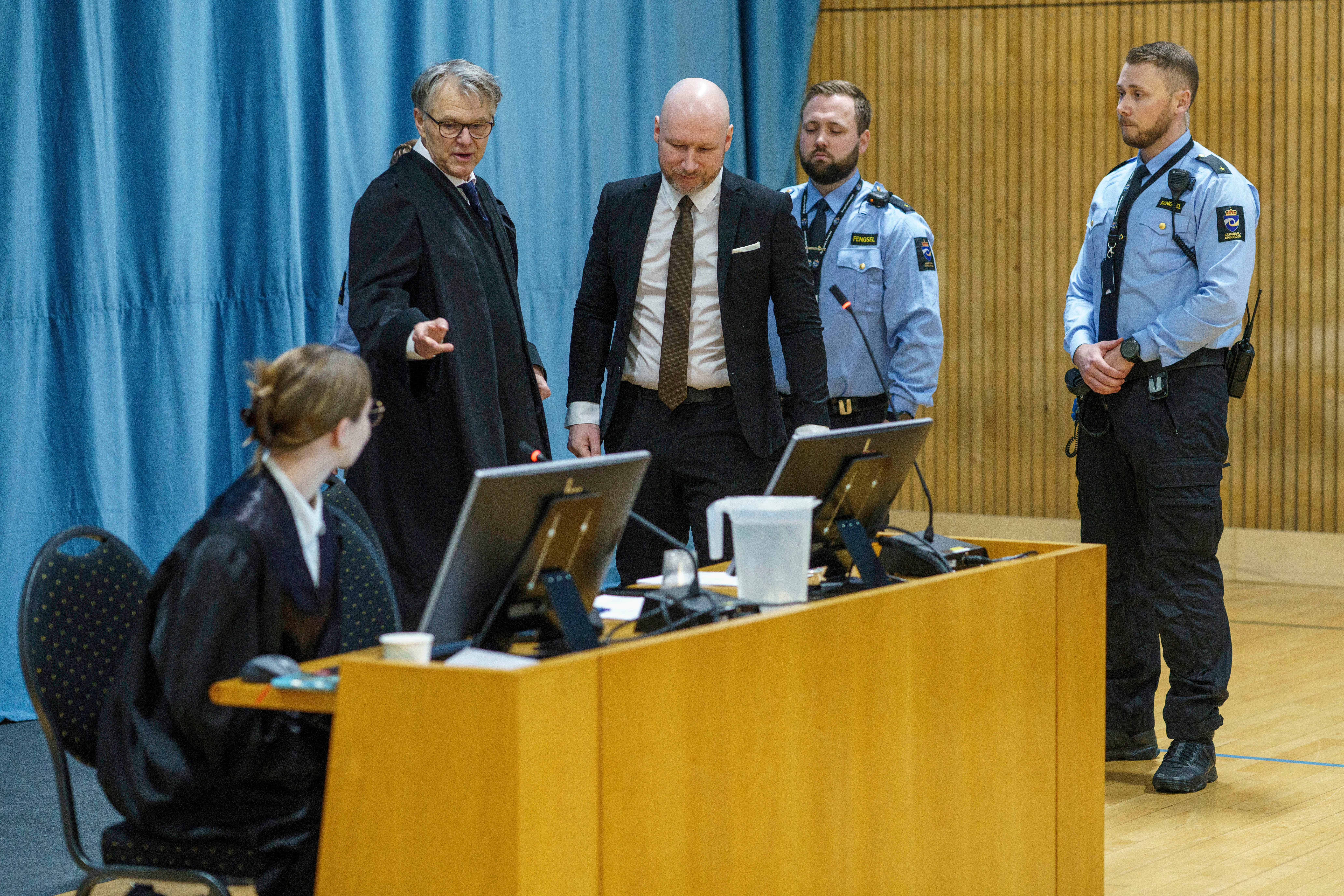 Anders Behring Breivik, center, arrives as the Oslo district court conducts his case in a gymnasium at Ringerike prison