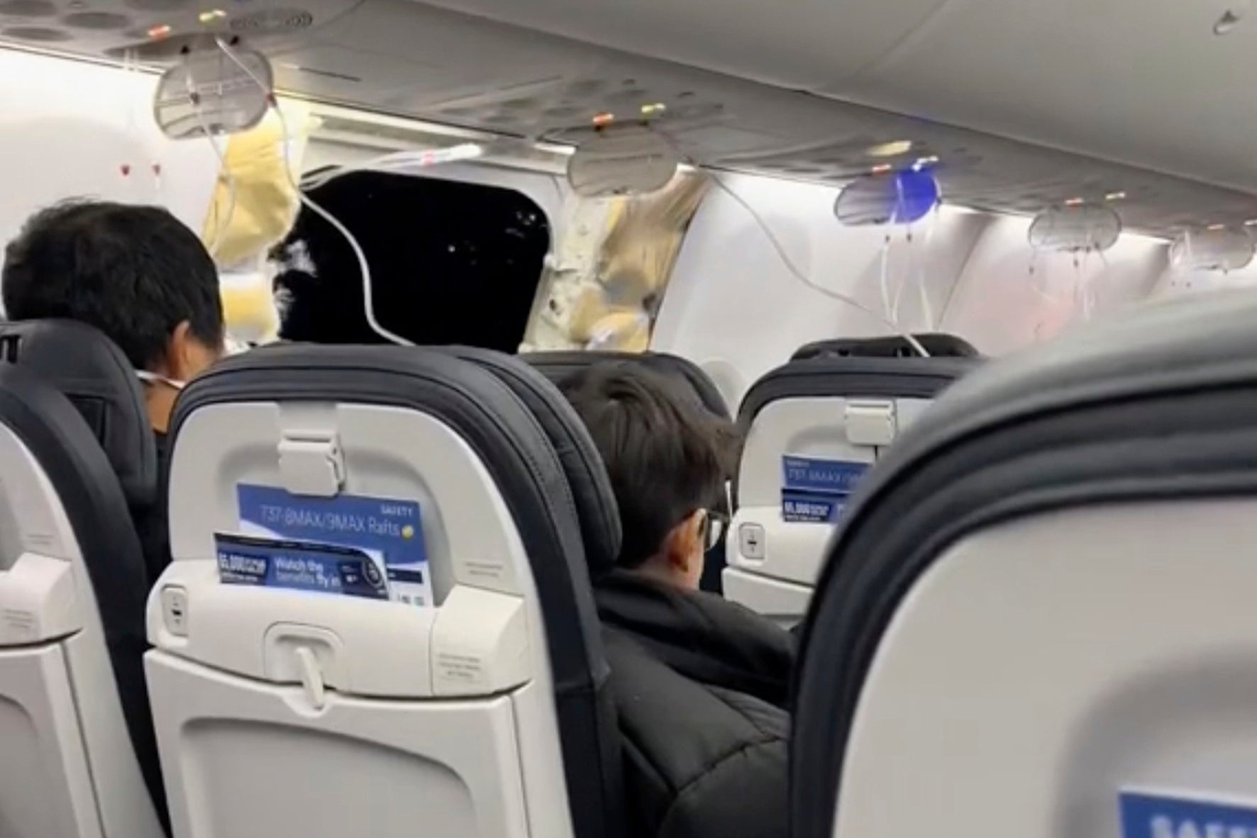 This image from a video provided by Elizabeth Le shows passengers near the damage on an Alaska Airlines Boeing 737 Max 9, Flight 1282, which was forced to return to Portland International Airport on Friday, 5 January 2024
