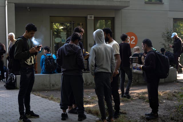 <p>Dozens of people from all over the world line in front of the central registration center for asylum seekers in Berlin</p>