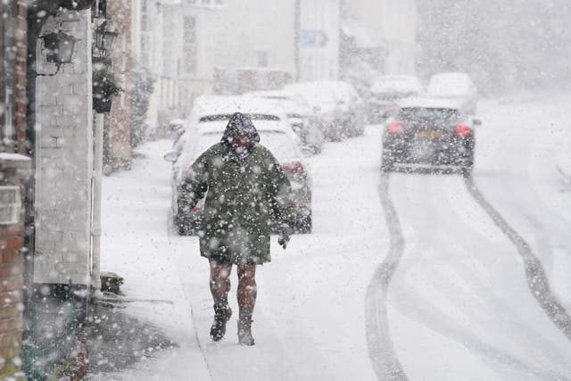 <p>A person walking through a snow flurry in Lenham, Kent, on Monday (Gareth Fuller/PA)</p>