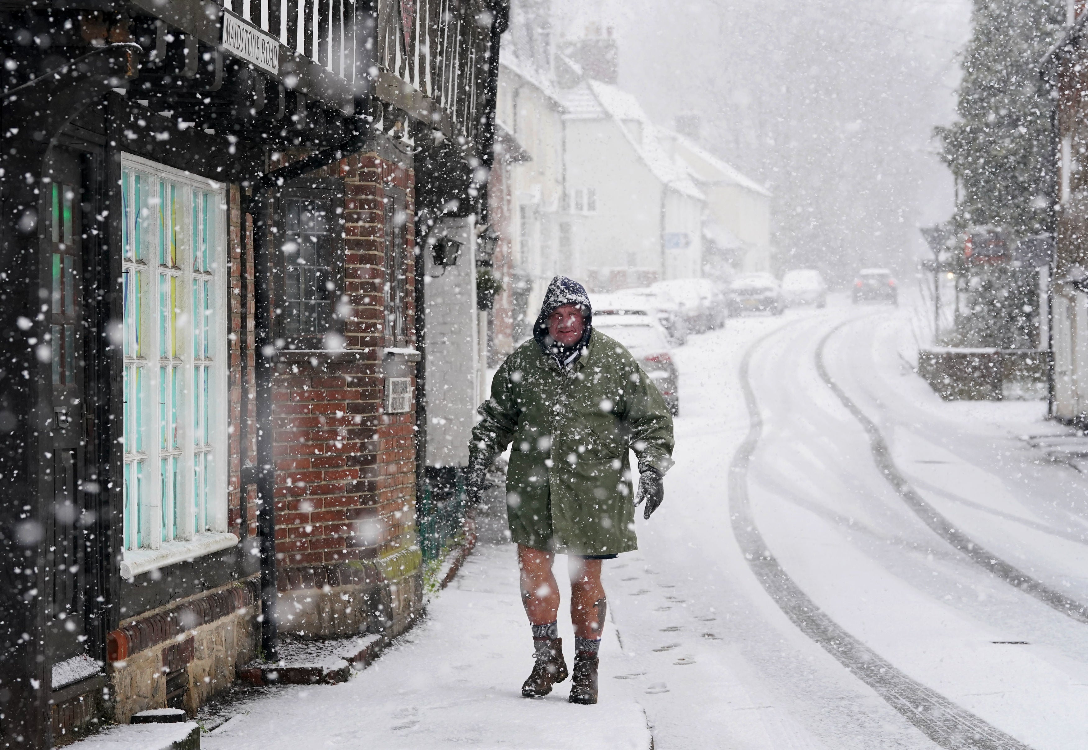 A man walks down a street in Lenham, Kent, as the town was covered in snow