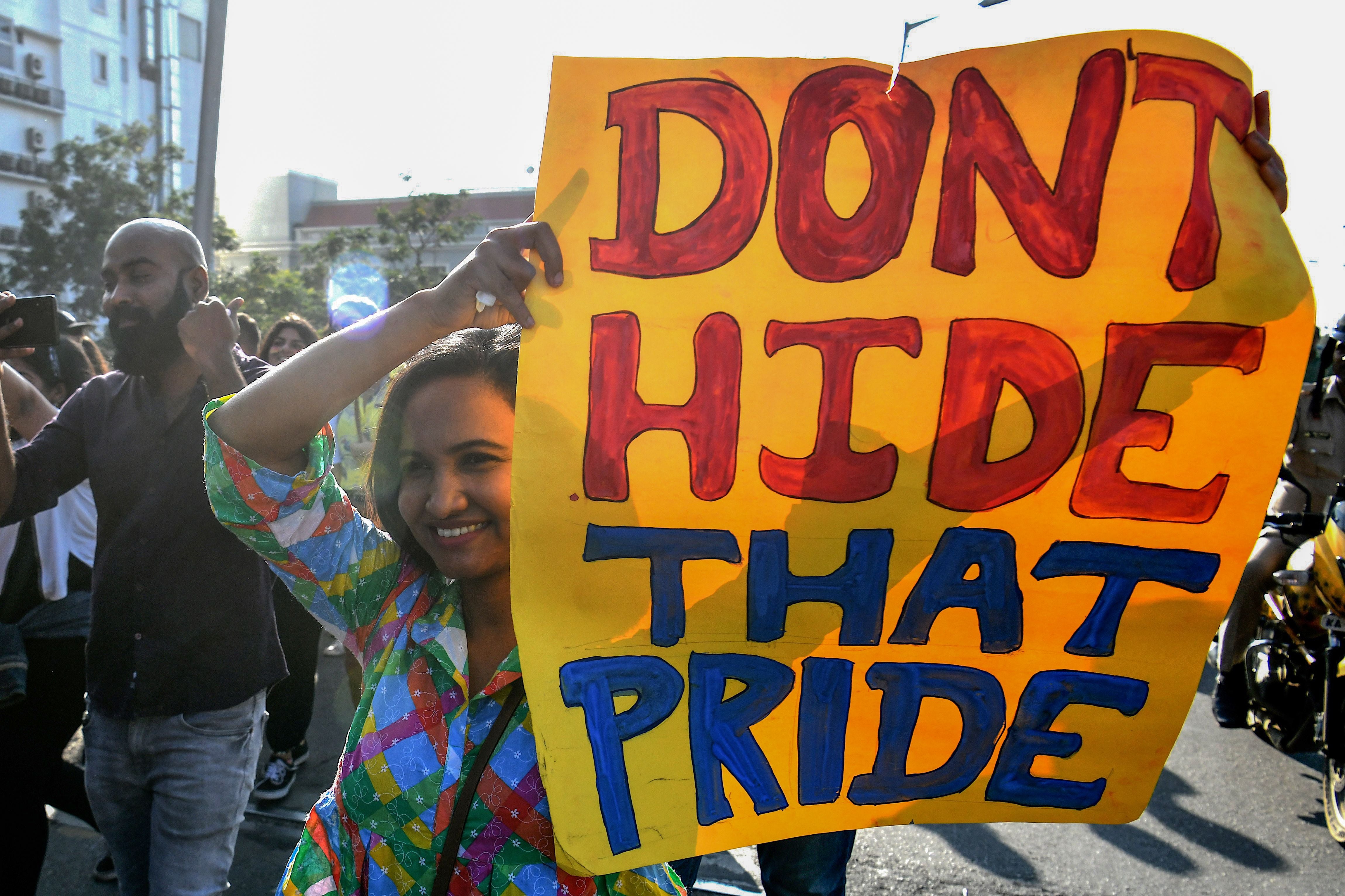 A member and supporter of the lesbian, gay, bisexual, transgender (LGBT) holds a placard while taking part in an annual pride parade