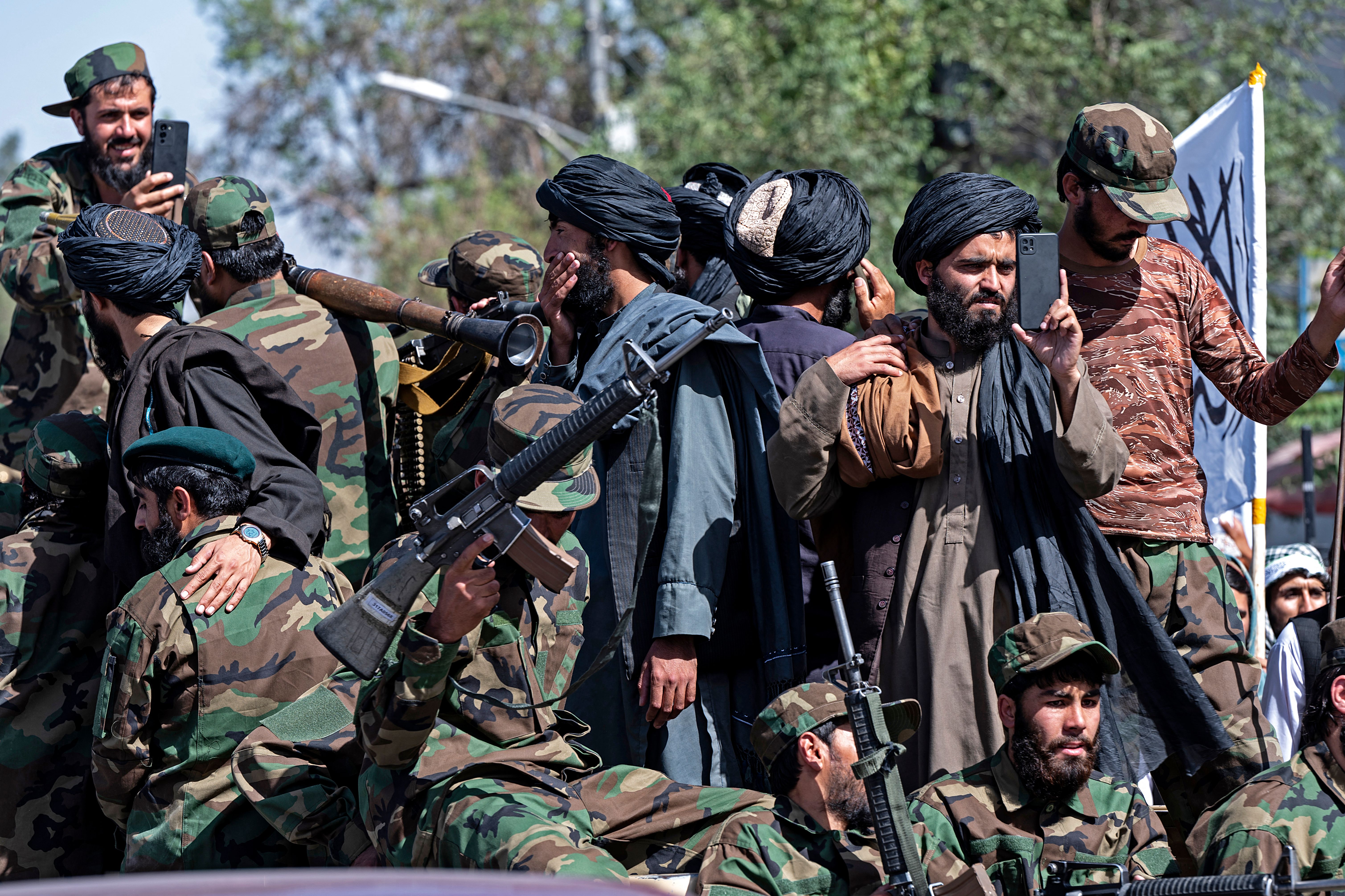 Armed Taliban security personnel ride a vehicle convoy as they parade near the US embassy in Kabul