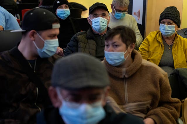 <p>People in face masks in a Barcelona hospital waiting room</p>