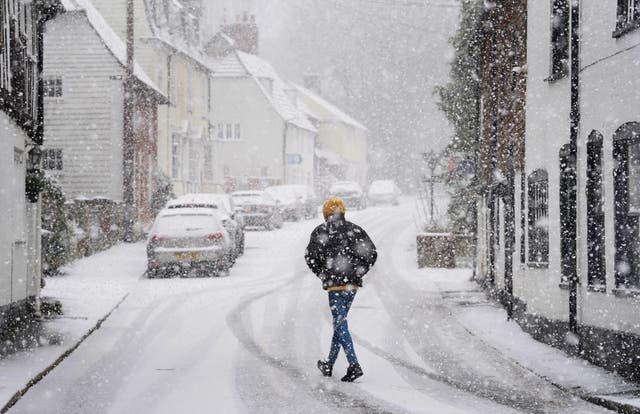 <p>A person walking through a snow flurry in Lenham, Kent.  Sleet and snow showers battered the UK on Monday </p>