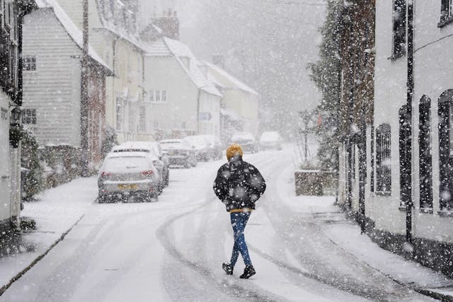 <p>A person walking through a snow flurry in Lenham, Kent.  Sleet and snow showers battered the UK on Monday </p>