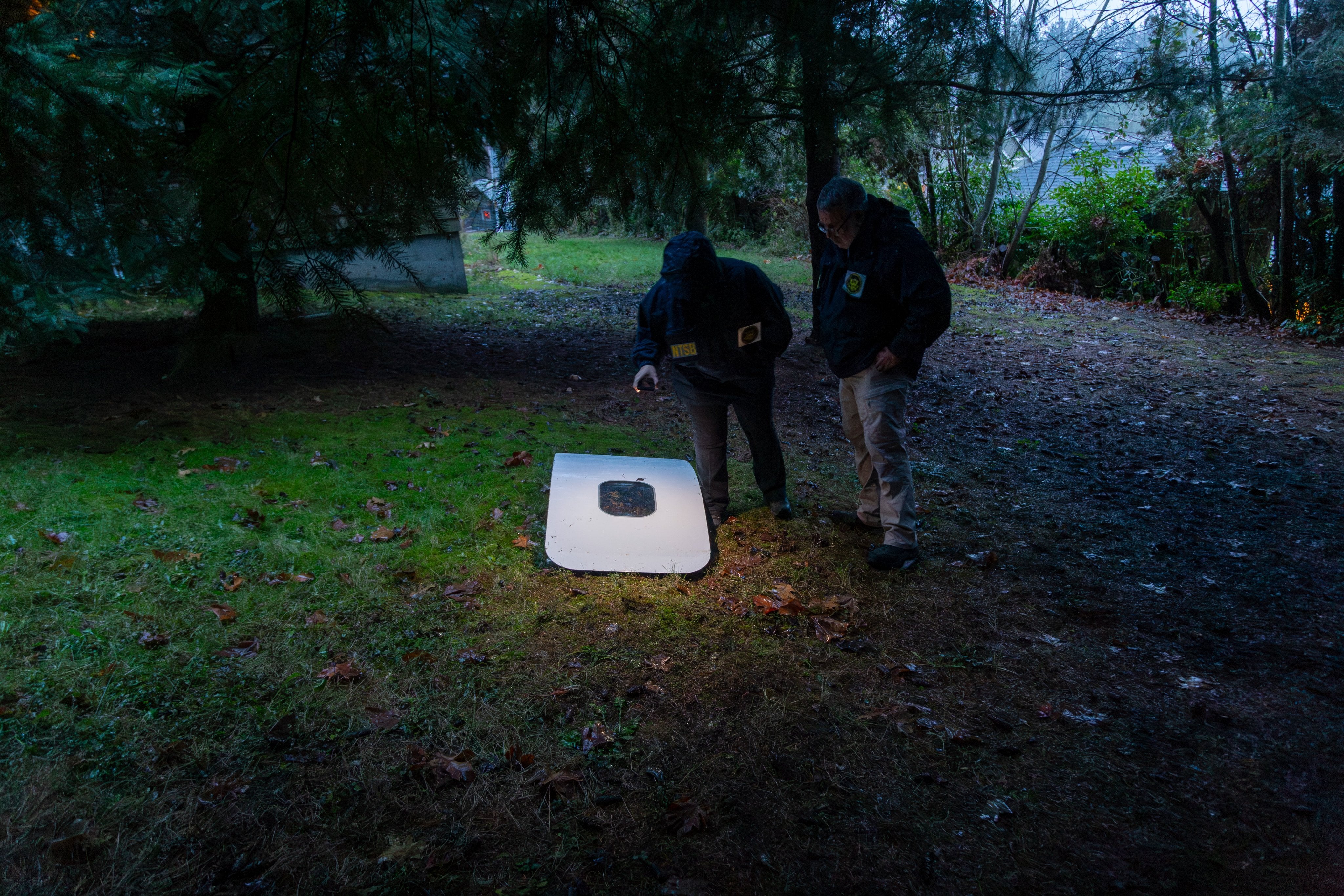 This handout image released by the National Transportation Safety Board (NTSB) shows agents inspecting the door plug from Alaska Airlines Flight 1282 on 8 January 2024 after being found in Portland, Oregon.