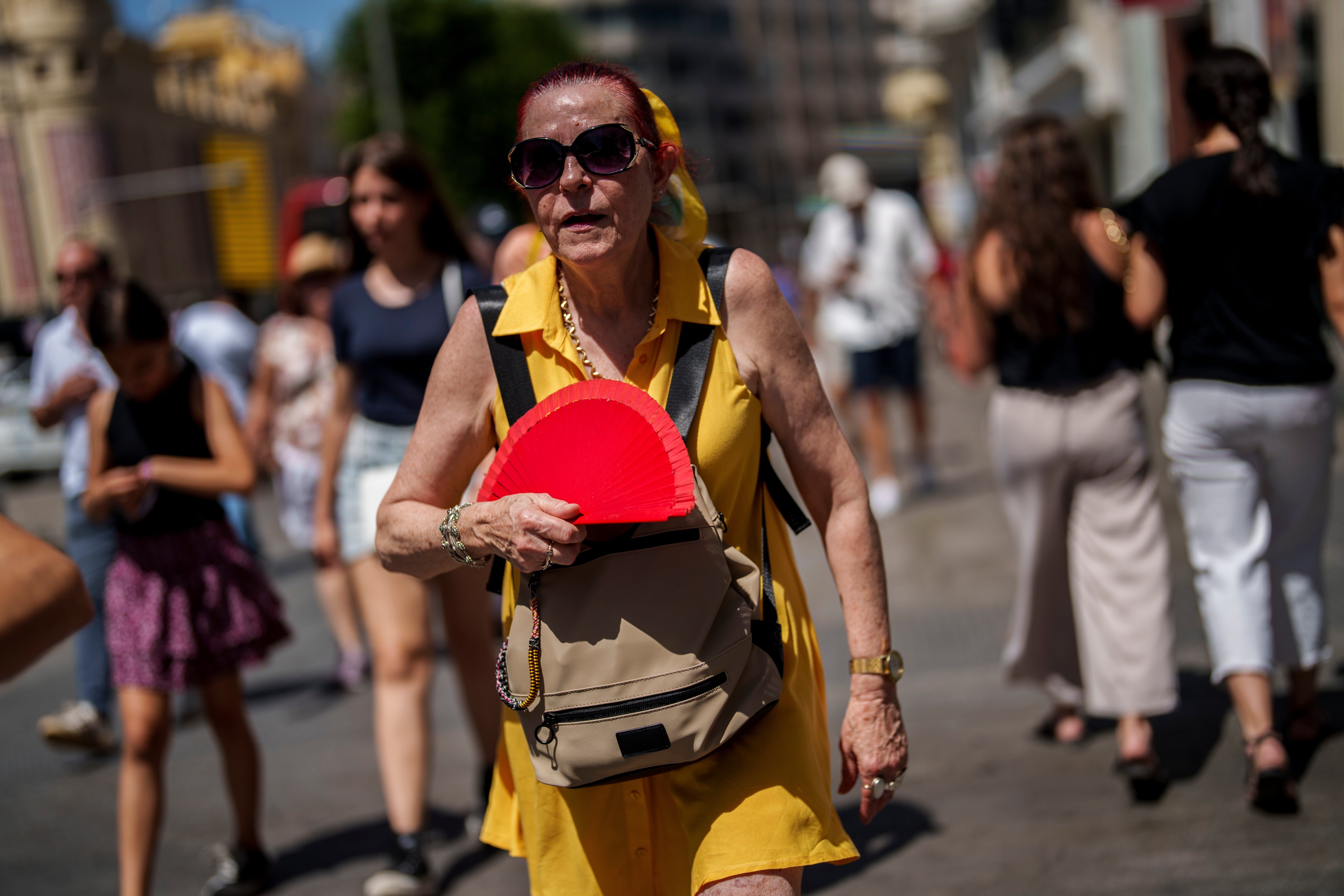 A woman fans herself in Madrid, Spain during heatwave in July 2023. Europe is the fastest heating continent
