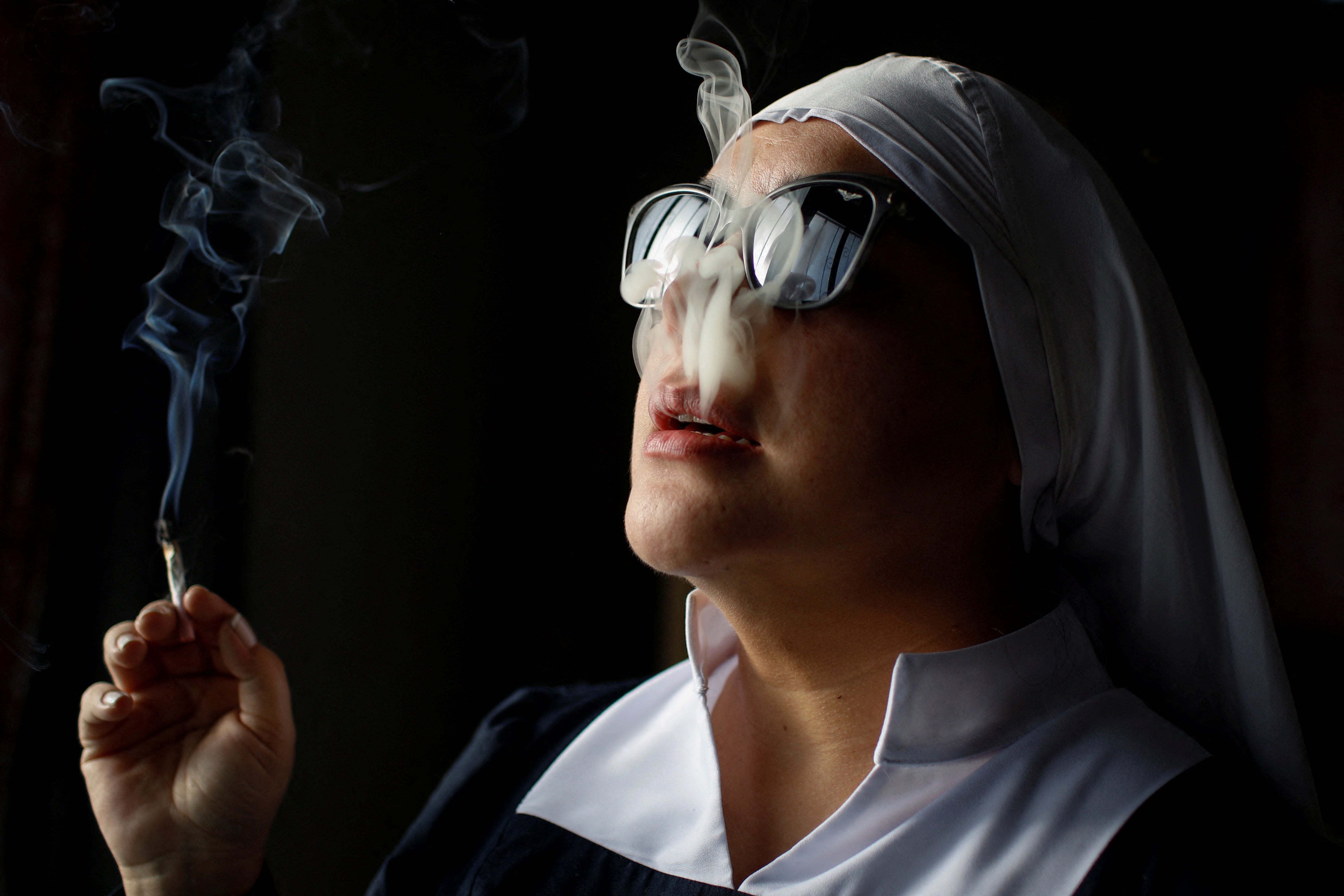 A member of Sisters of the Valley, a non-religious international group founded in 2014, smokes a joint at the group’s farm on the outskirts of a village in central Mexico