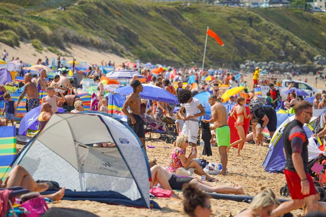 <p>Holidaymakers fill the beach in Newquay - but an inquiry report by Cornwall Council says a spike in visitors can have a negative impact</p>