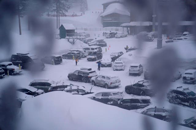 <p>People through the parking area of the Alpine Base Area at Palisades Tahoe during a winter storm Friday, Feb. 24, 2023, in Alpine Meadows, California </p>