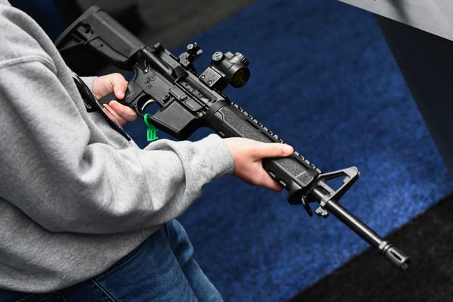 <p>A National Rifle Association event attendee holds an AR-15-style rifle in Texas on 28 May, 2022. </p>
