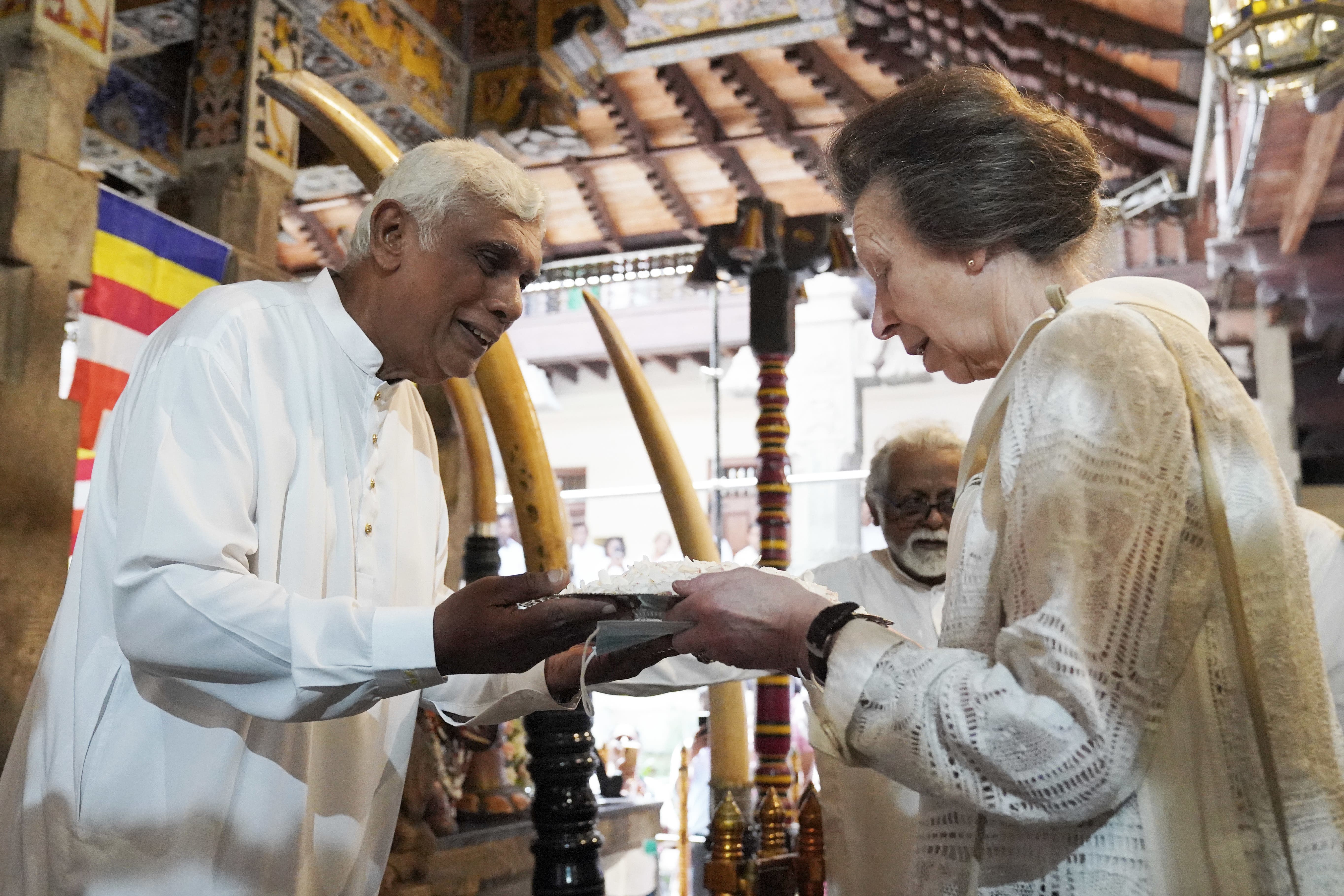The Princess Royal prepares to offer jasmine flowers during a visit the Temple of the Sacred Tooth Relic in Kandy (Jonathan Brady/PA)