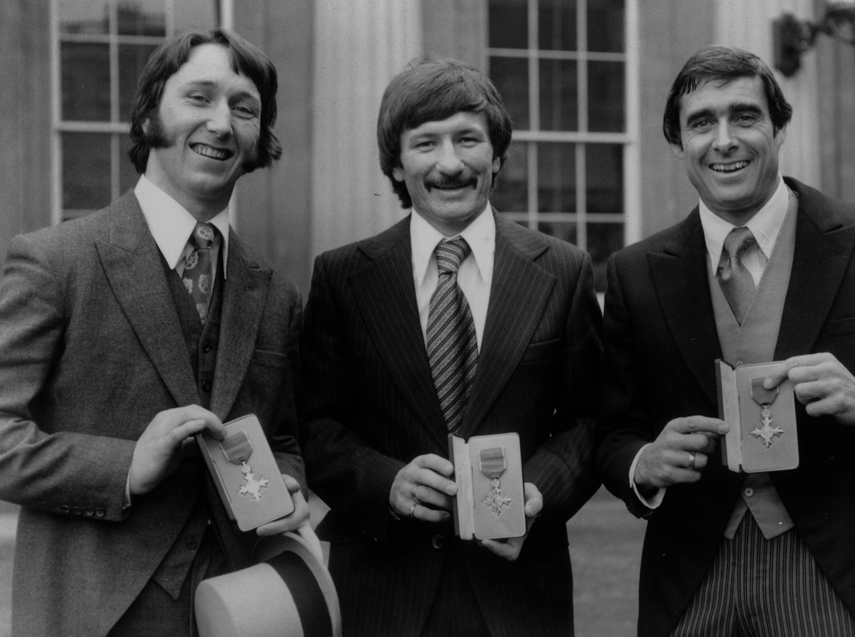 JPR Williams (left), footballer Tommy Smith (centre) and tennis player Roger Taylor (right) outside Buckingham Palace after they were all awarded the MBE in December 1977