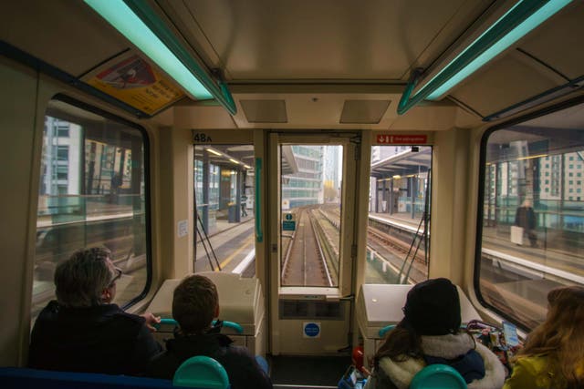 The front seats of DLR services are often filled by transport enthusiasts young and old pretending to drive the train (Alamy/PA)