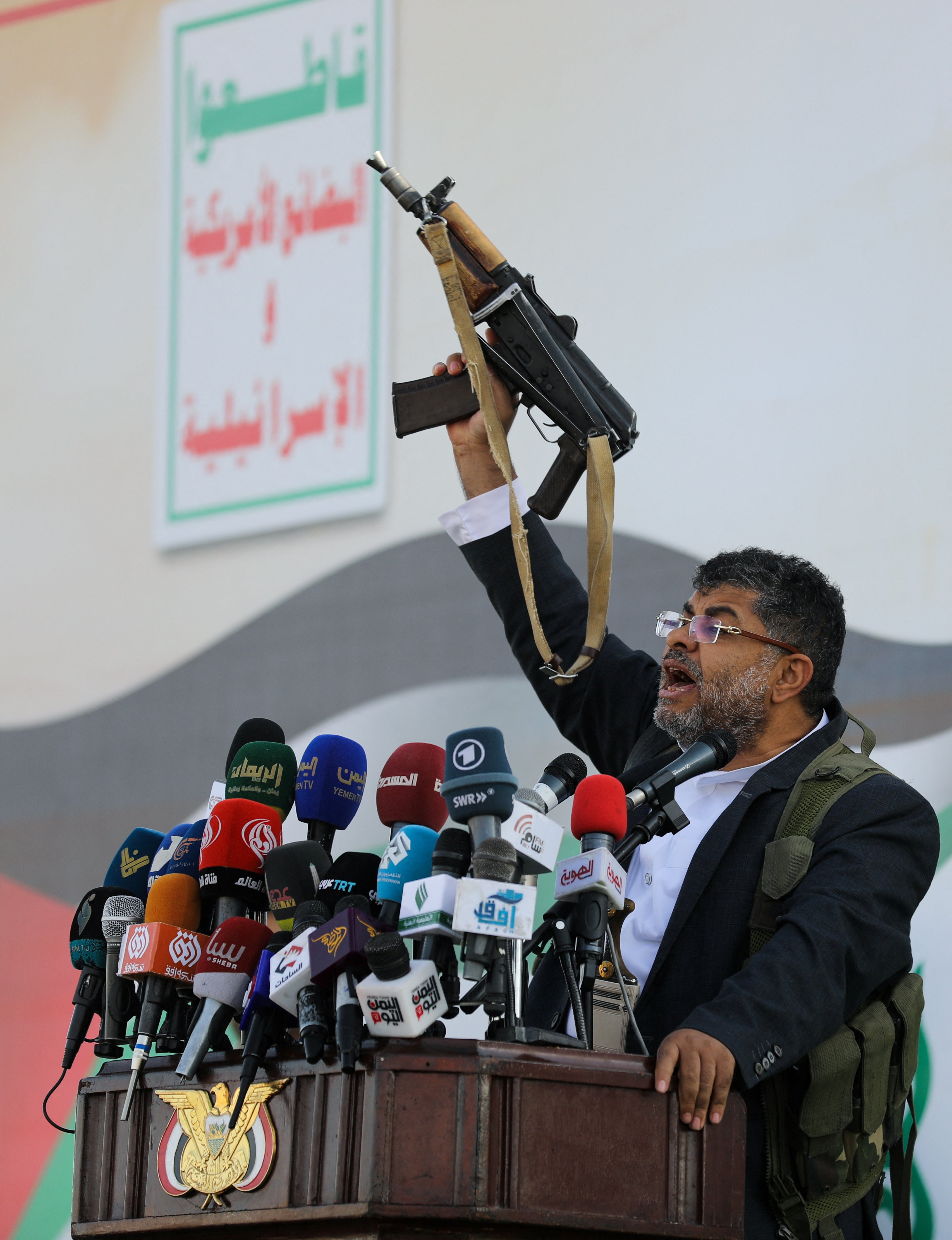 <p>Mohammed Ali al-Houthi, a member of the Houthi supreme political council, speaks while holding a gun, as supporters of the Houthi movement rally to denounce air strikes launched by the US and Britain on Houthi targets, in Sanaa, Yemen 12 January 2024</p>