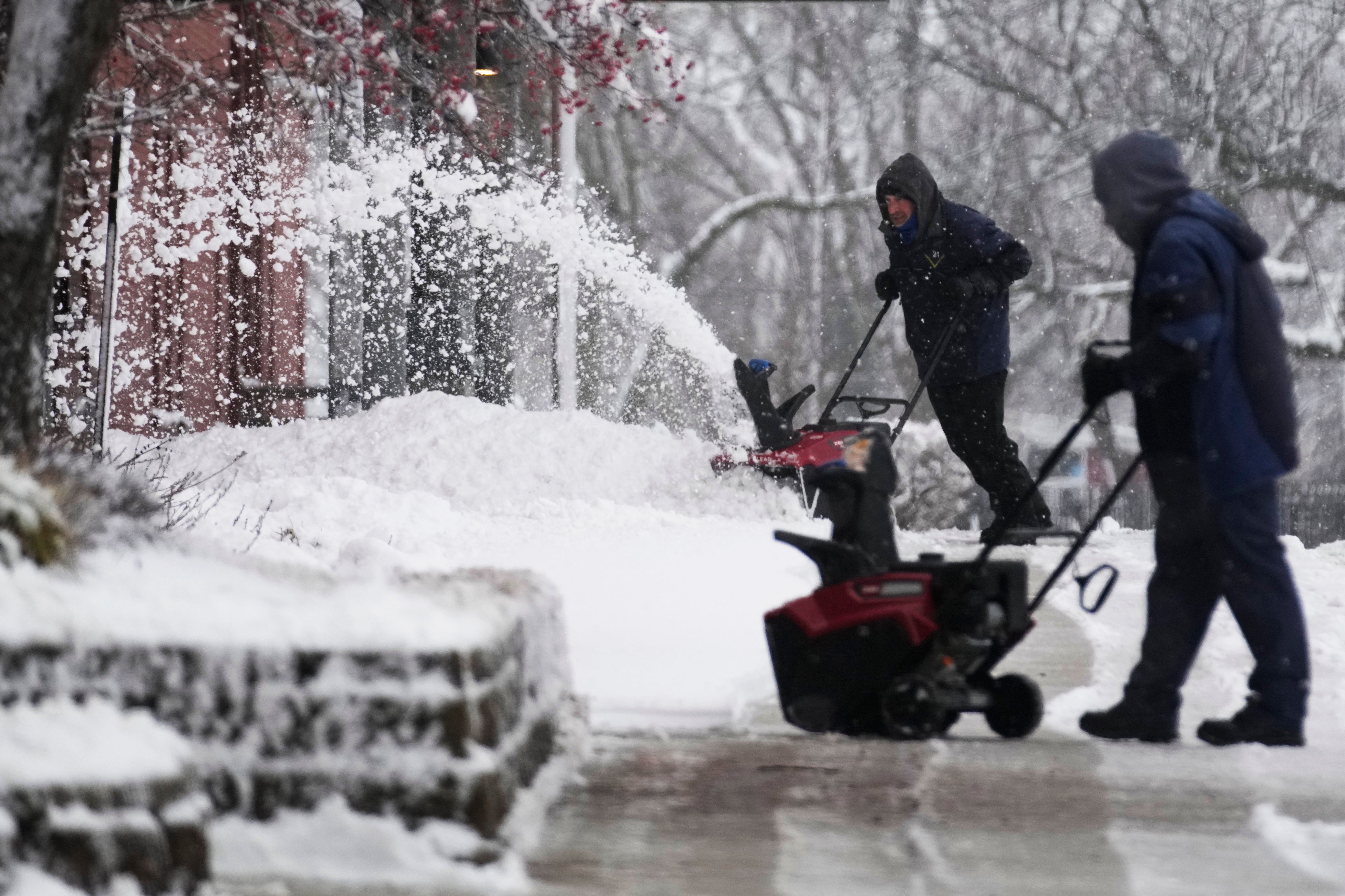 People clean a path from snow in front of a school in Wheeling, Illinois