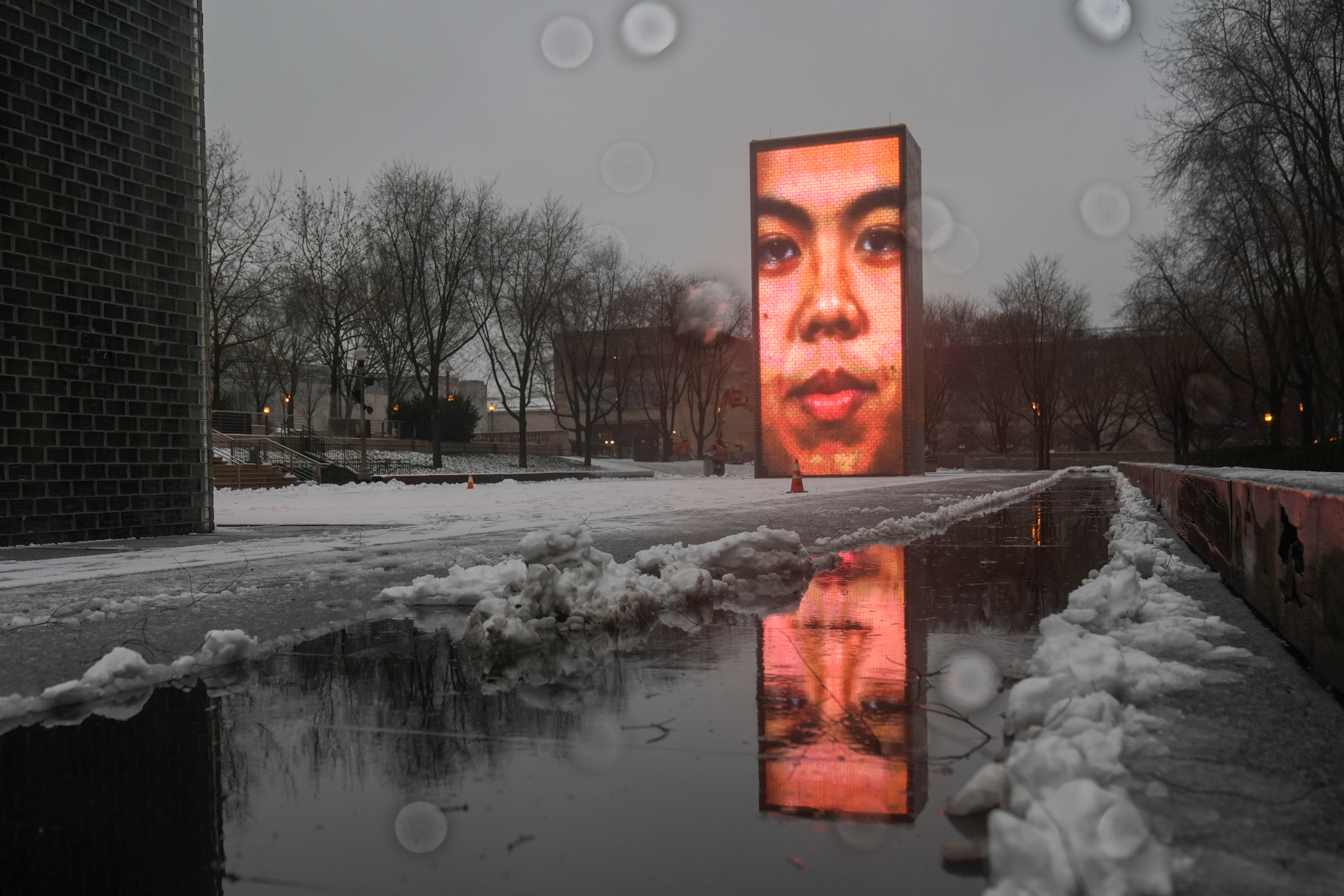 Snow falls on the Crown Fountain in Millennium Park during a winter storm, Friday, Jan. 12, 2024, in Chicago