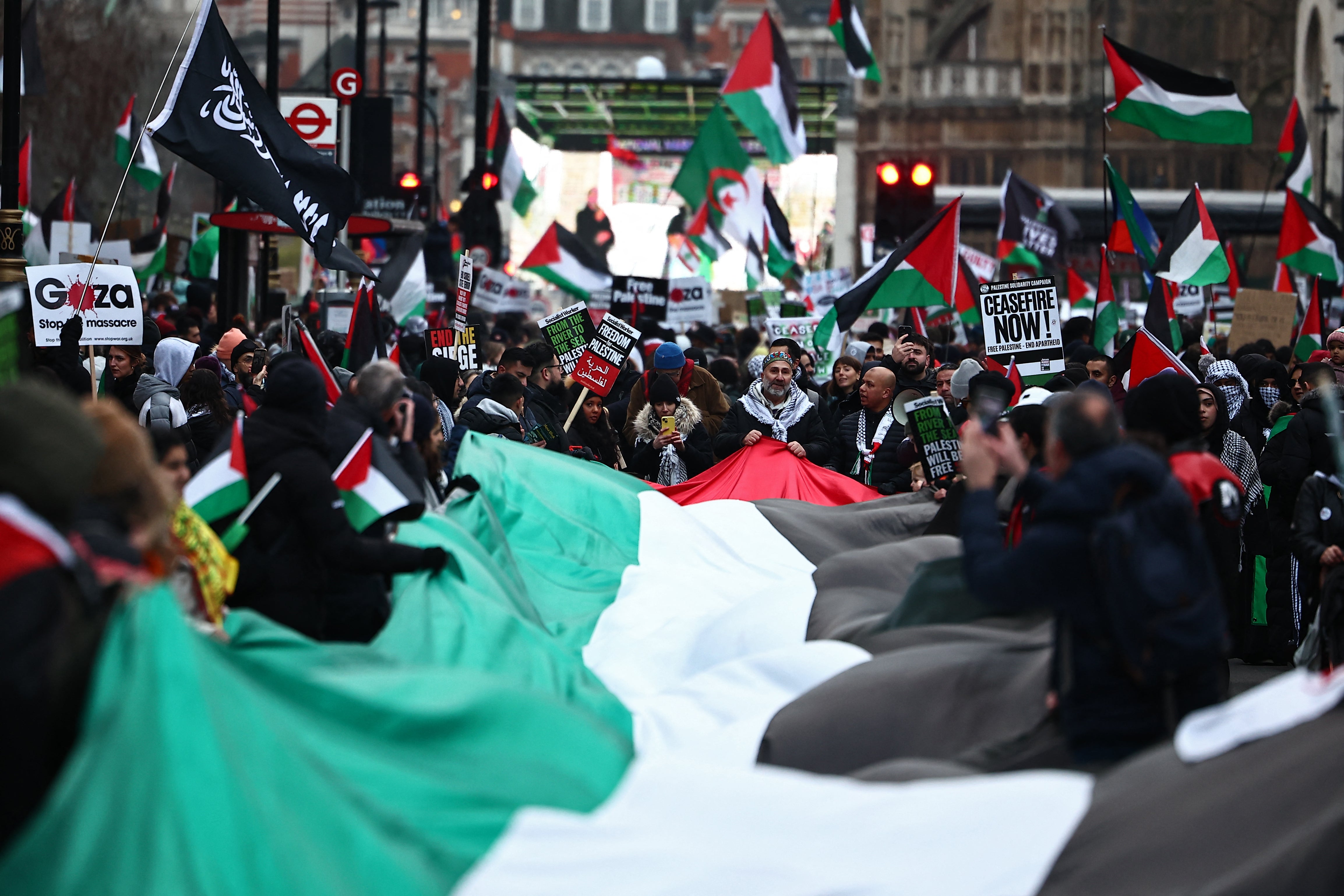 Pro-Palestinian activists and supporters display a large Palestinian flag during a national march for Palestine in central London