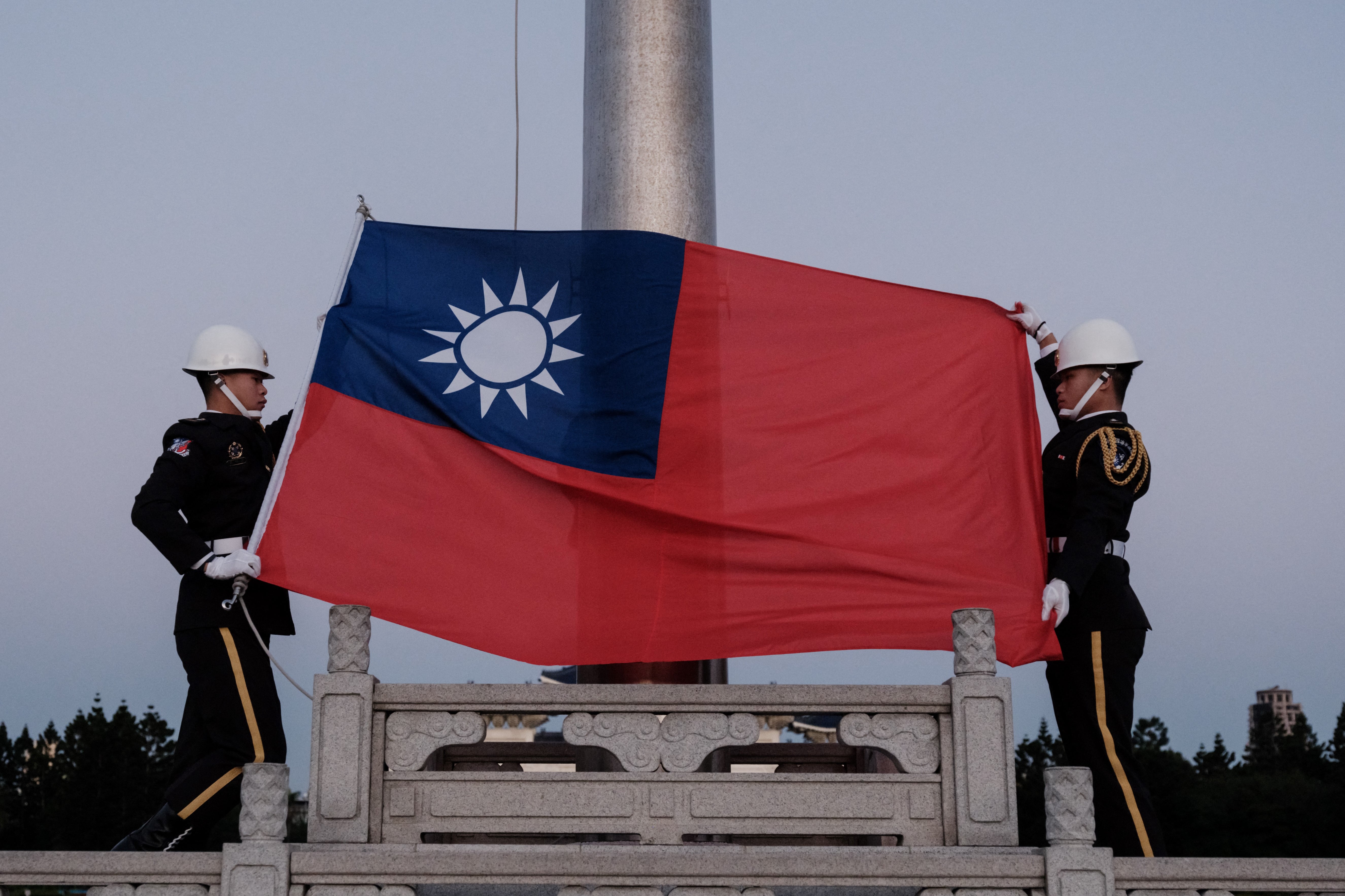 Guards raise Taiwan’s national flag on Democracy Boulevard at the Chiang Kai-shek Memorial Hall in Taipei on Sunday