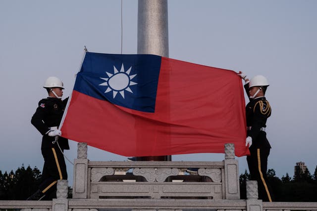 <p>Guards raise Taiwan’s national flag on Democracy Boulevard at the Chiang Kai-shek Memorial Hall in Taipei on Sunday </p>