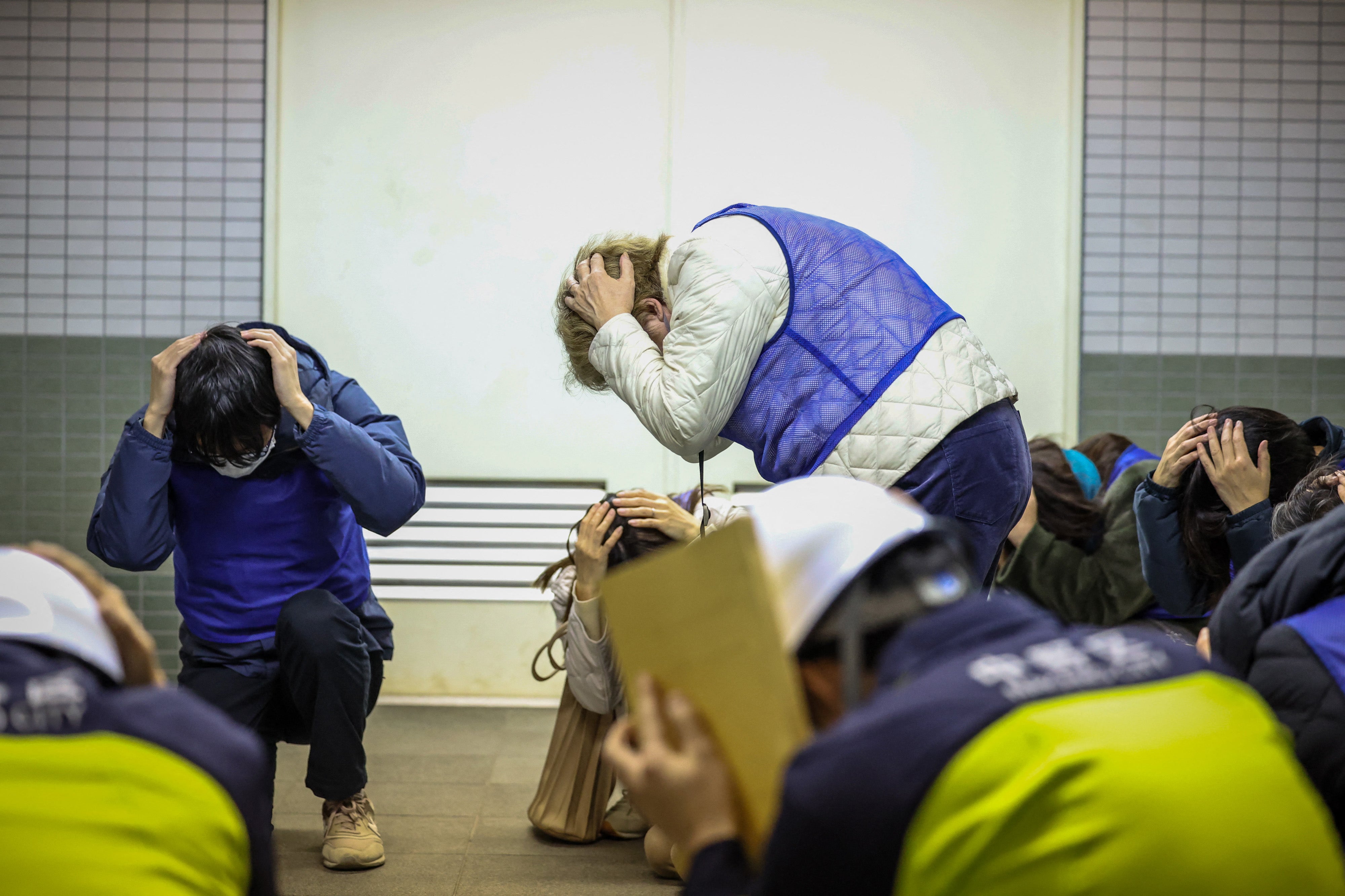 Residents are seen moving through the Toei Subway Higashi-Nakano Station during a security drill for the evacuation of residents and others to underground stations after a J-Alert is issued, in Tokyo