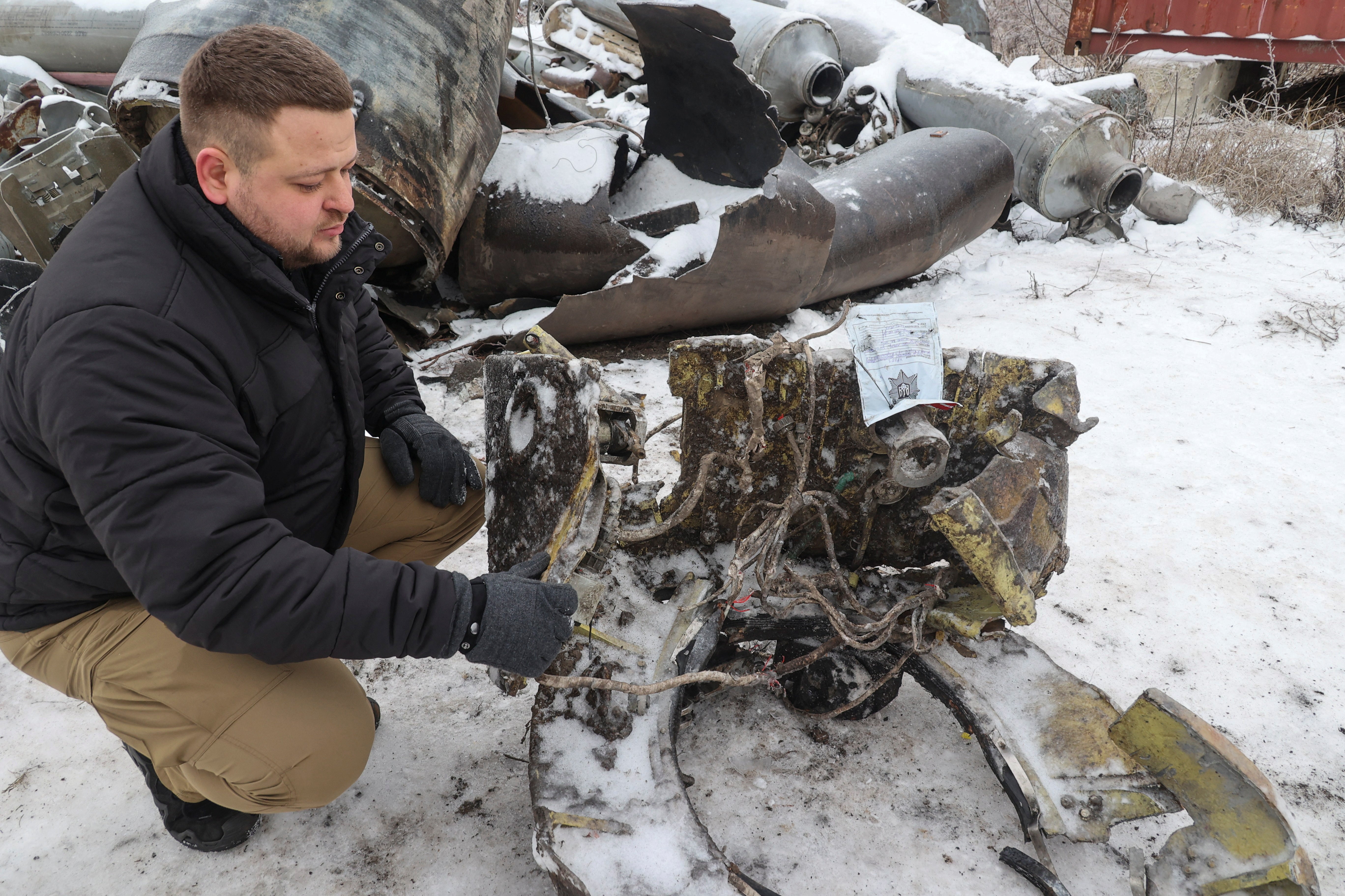 A representative from the prosecutor's office shows parts of an unidentified missile, which Ukrainian authorities believe to be made in North Korea and was used in a strike in Kharkiv