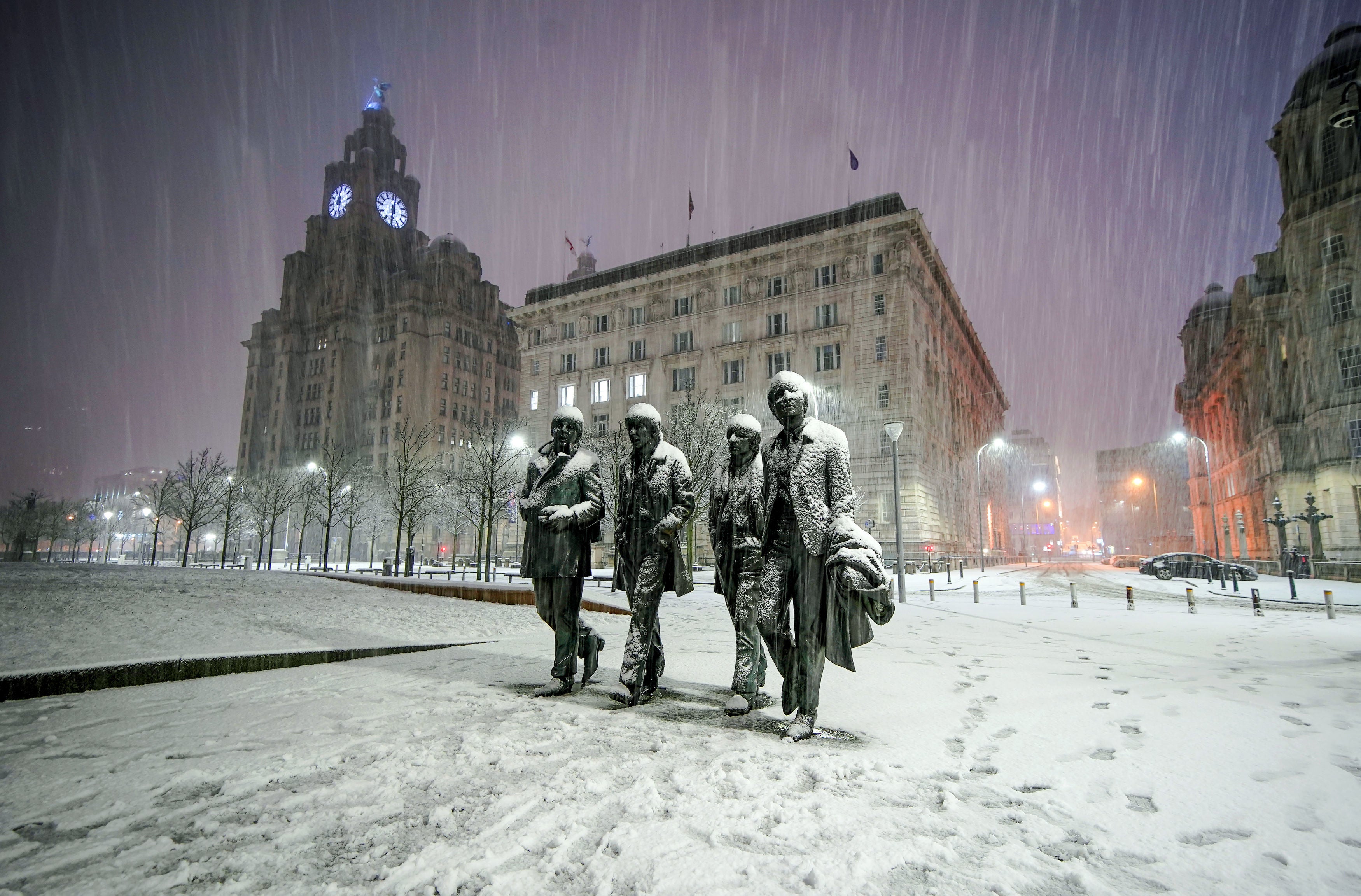 <p>Snow falls on the Beatles Statue at Pier Head, Liverpool</p>