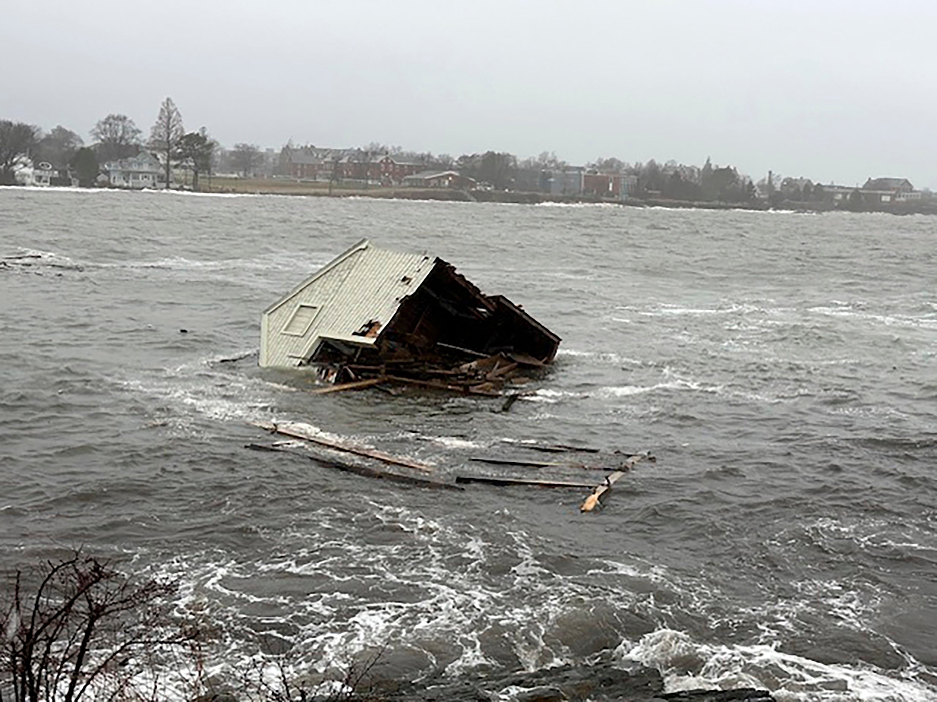 A fishing shack floats away into Casco Bay during a storm in South Portland, Maine