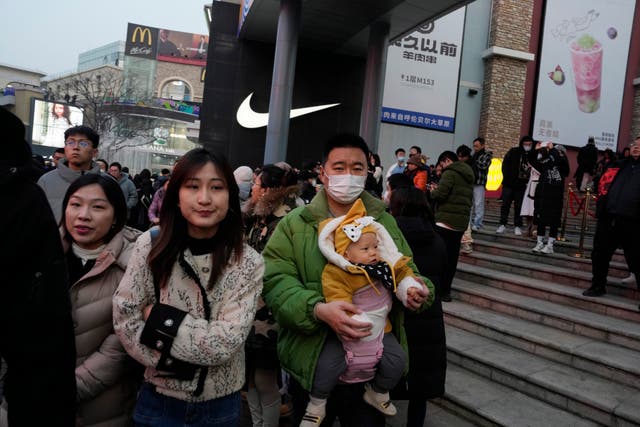 <p>A man is pictured holding a baby at a Beijing shopping mall – but there are too few Chinese being born  </p>