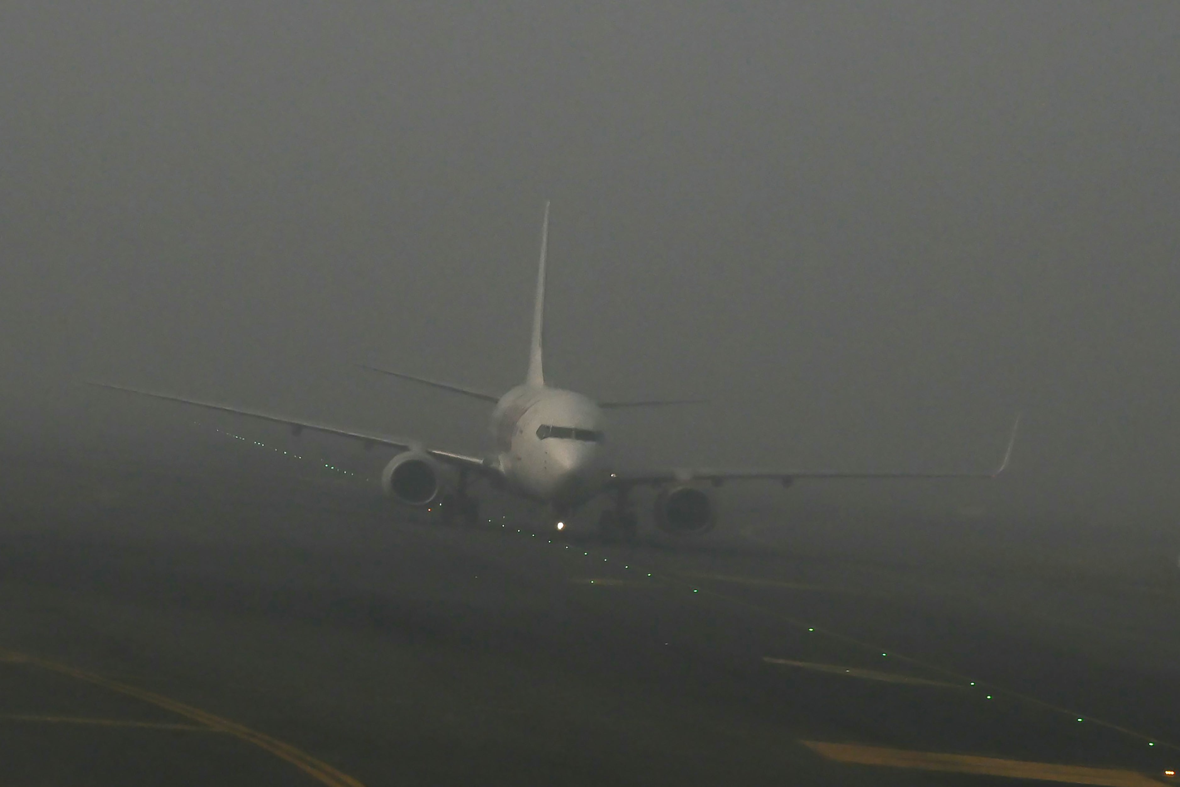 An aircraft prepares to take off amid dense fog on a cold winter morning at Indira Gandhi International Airport in New Delhi