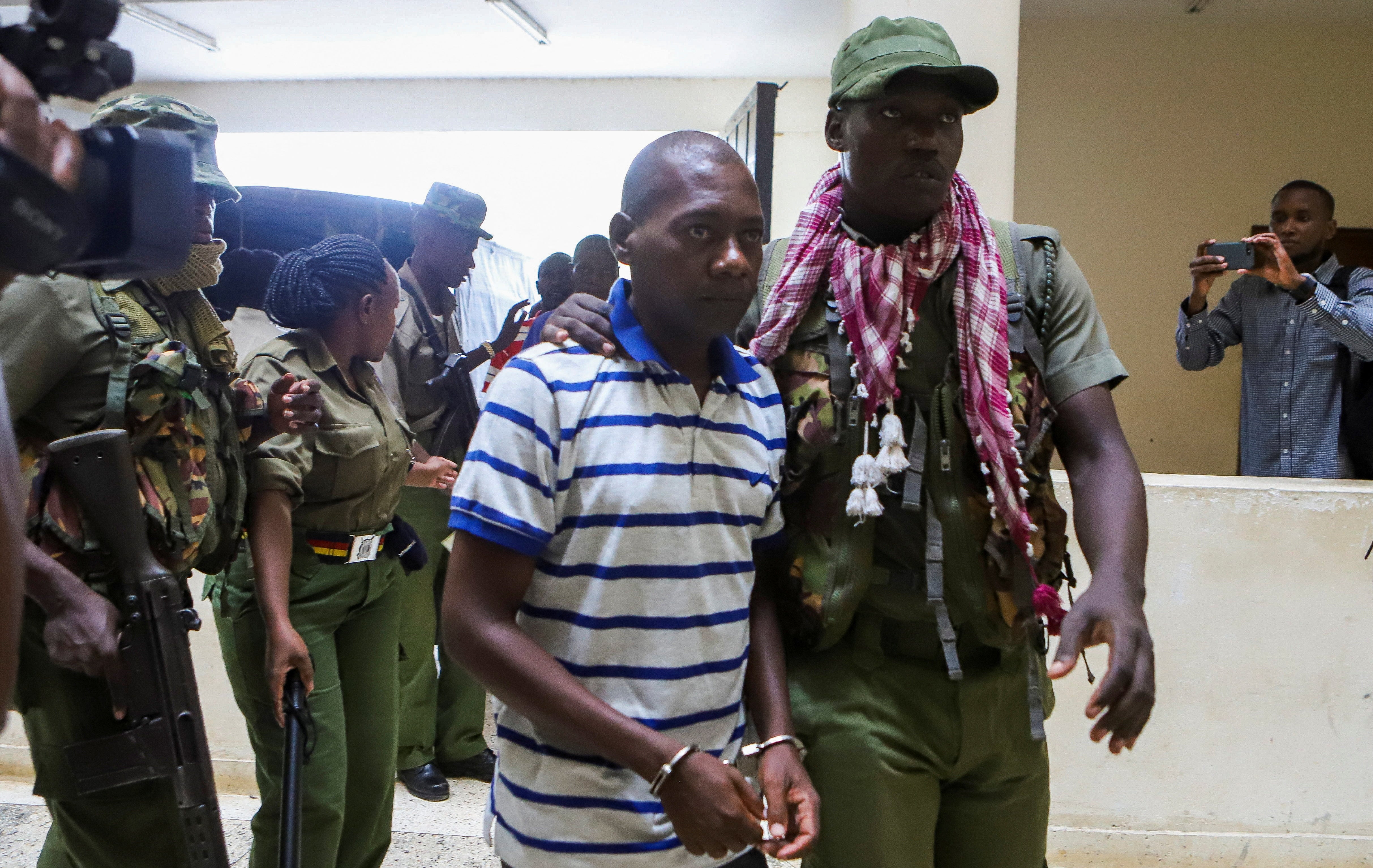 <p>Paul Mackenzie, a Kenyan cult leader accused of ordering his followers, is escorted to the Malindi Law Courts on Wednesday </p>