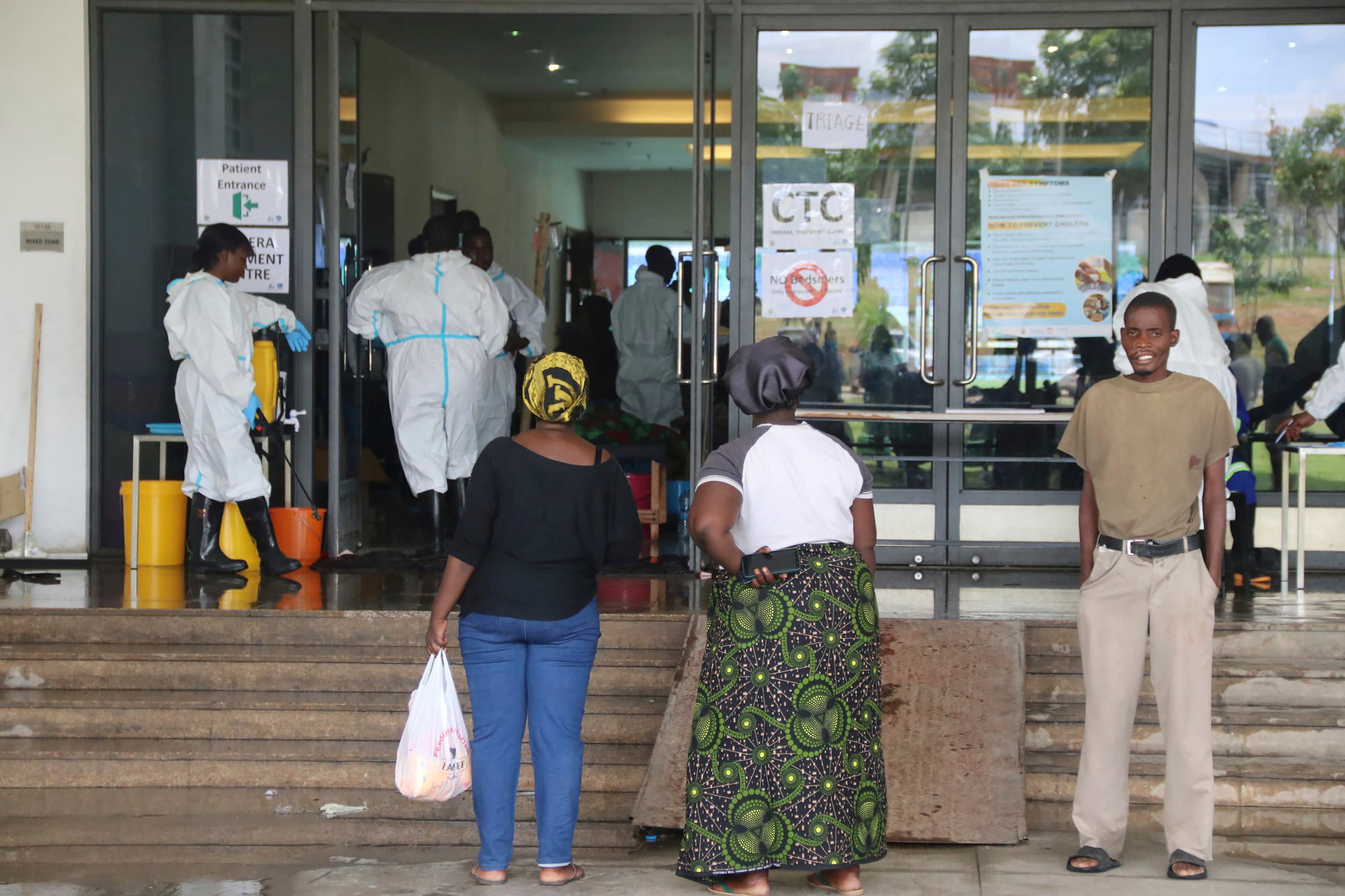 People wait outside a cholera treatment centre, in Lusaka, Zambia, Friday, January 12, 2024